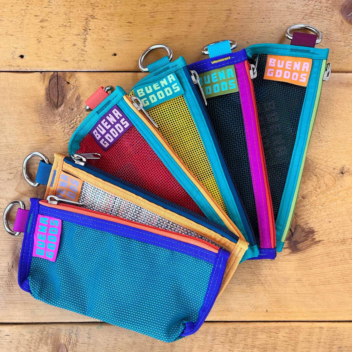 Vibrant color mesh pouches with keyring attachments, showcasing The Catch Pouch in various bright hues and trims.