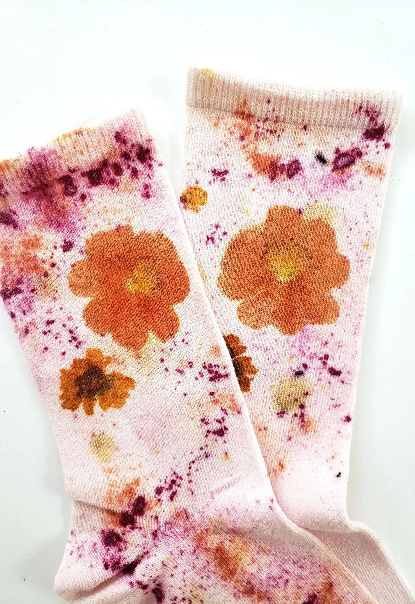 Pair of Flower Power Cotton Crew Sock with orange floral prints on soft white fabric background