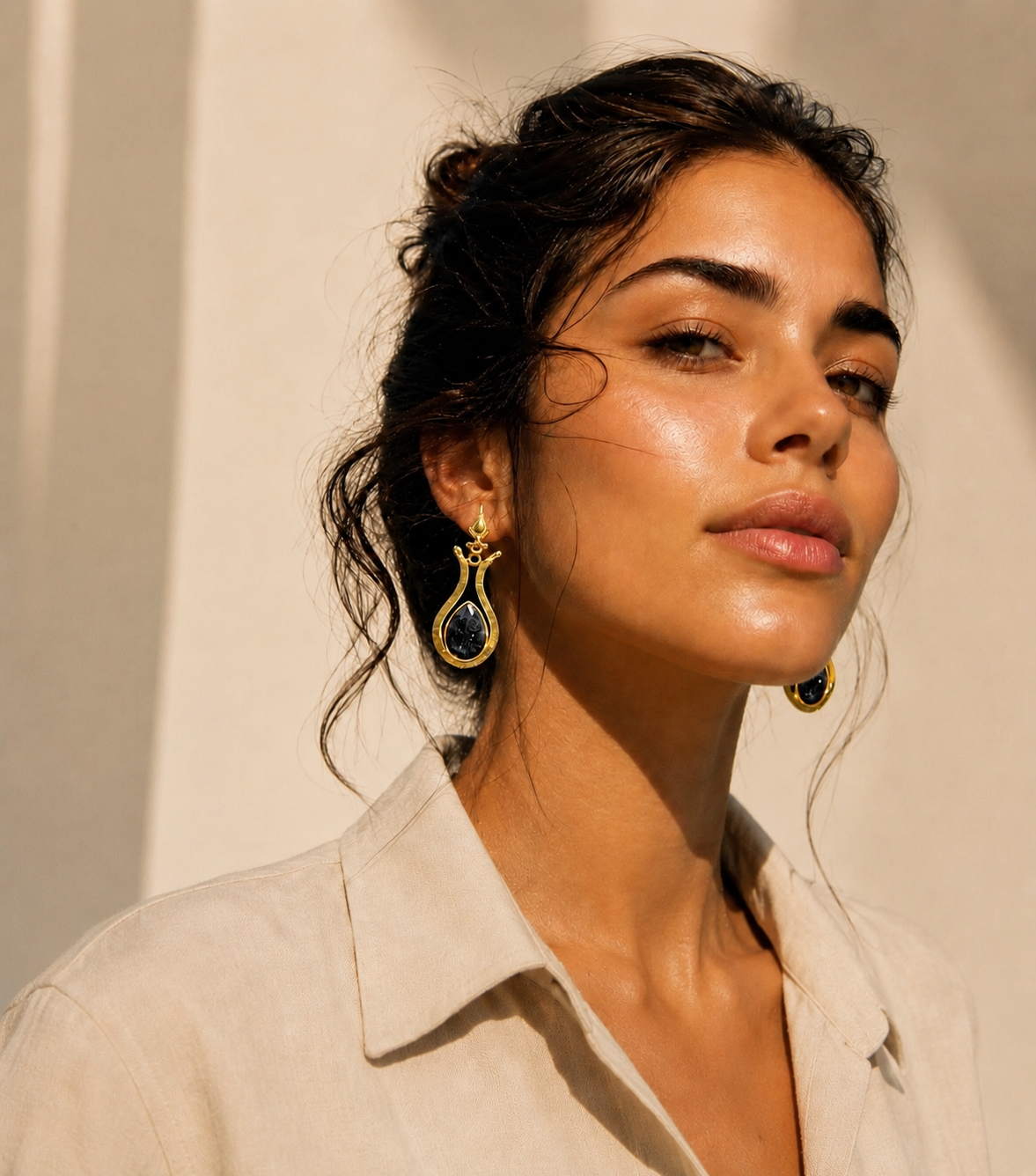 Lapis Lazuli and Gold Drop Earrings worn by a model with blue stones and gold settings