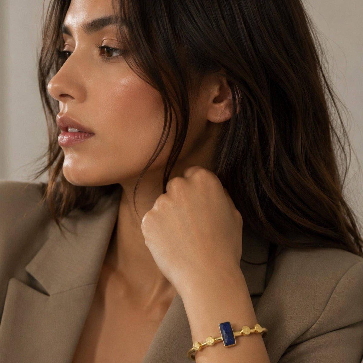 Harem Lapis Lazuli Bangle worn with gold accents and a blue stone on a woman’s wrist