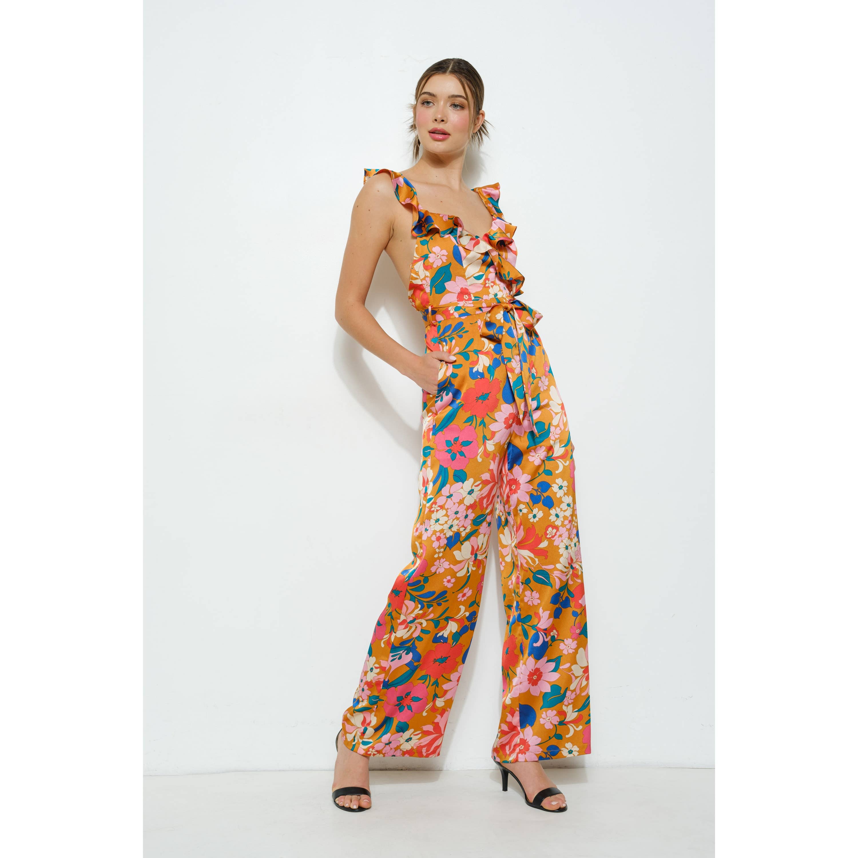 Woman wearing a colorful floral jumpsuit on a white background