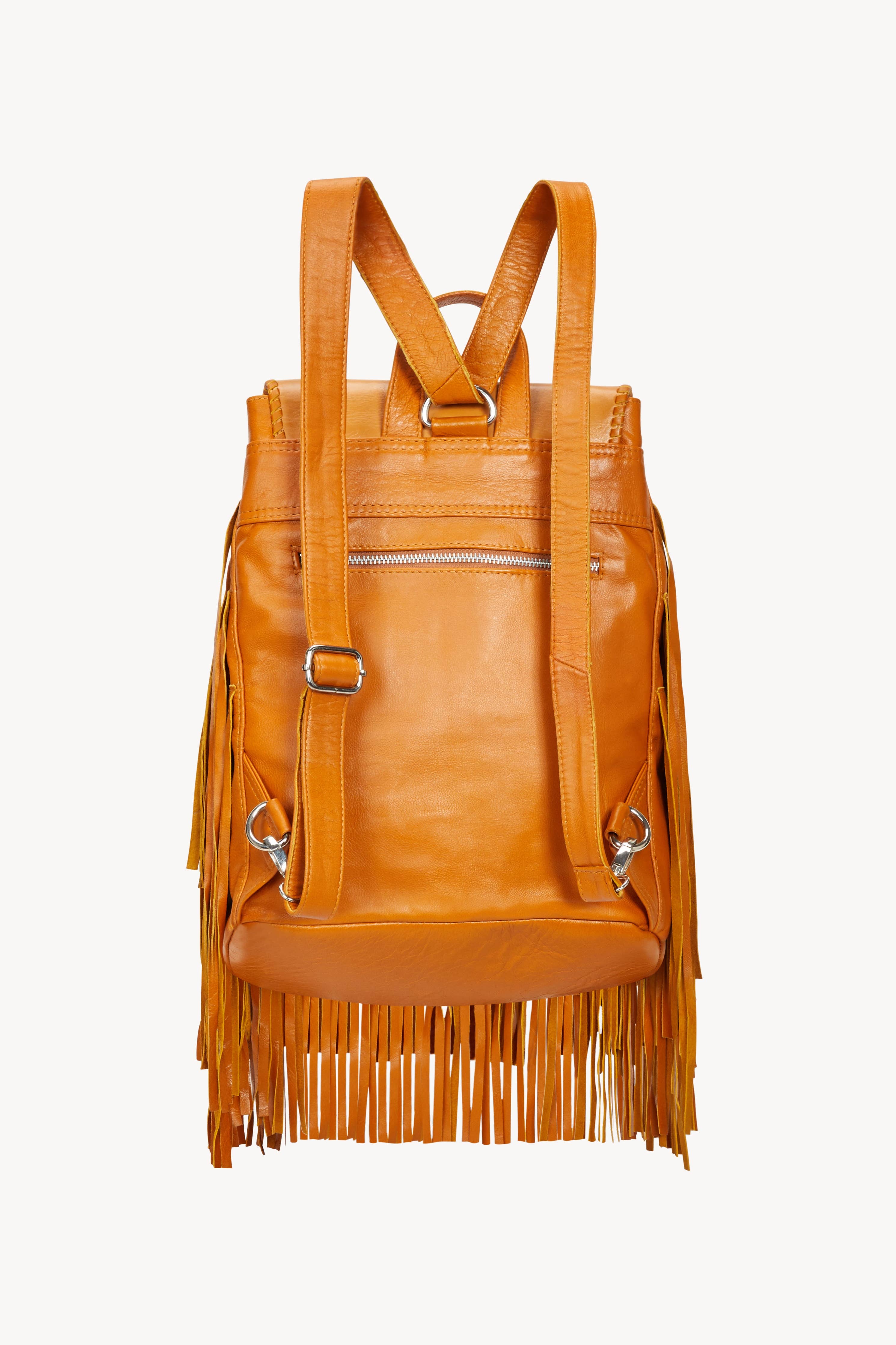 The Jodi Lee Monterey Backpack Antique Tan is handmade from antique tan cow leather, with long fringe sides, adjustable shoulder straps, and a silver zipper pocket on the back.