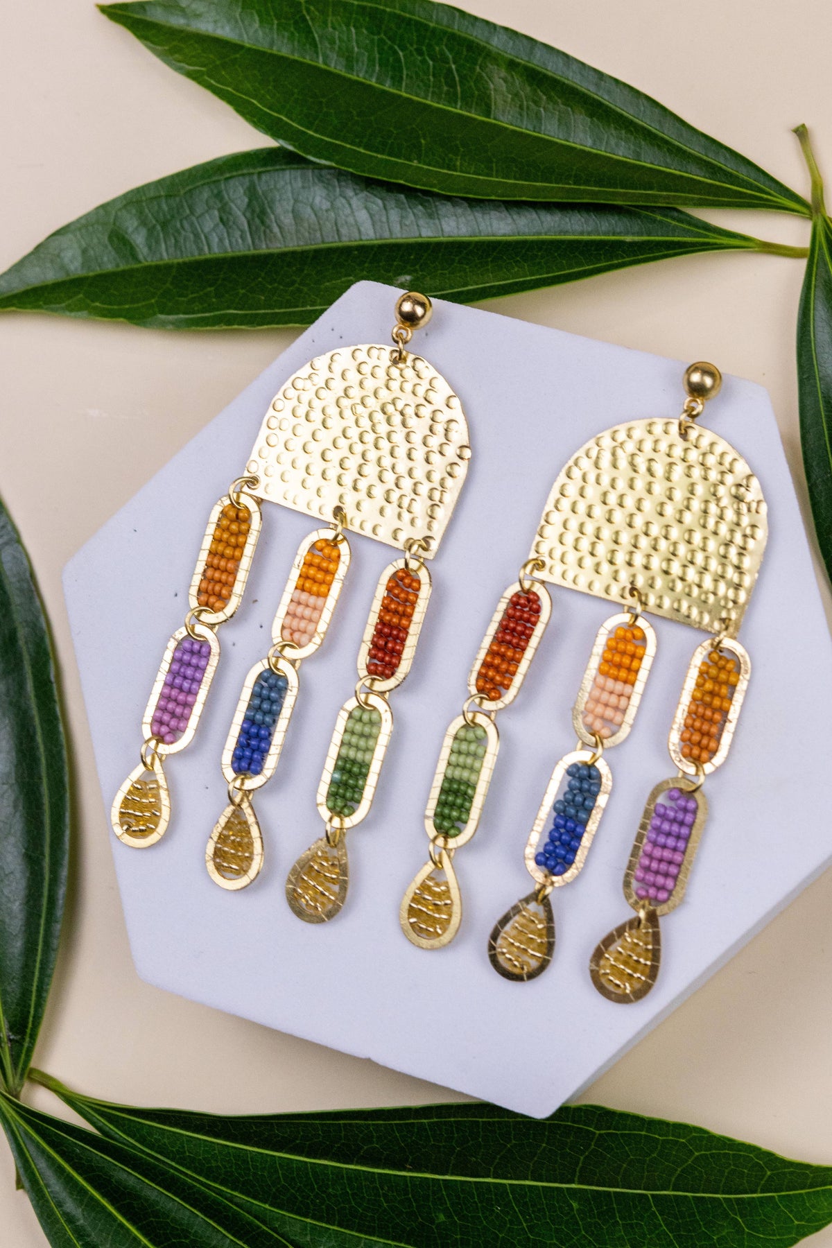 Iris Sun Earrings colorful beaded statement earrings with gold accents on a lavender display card