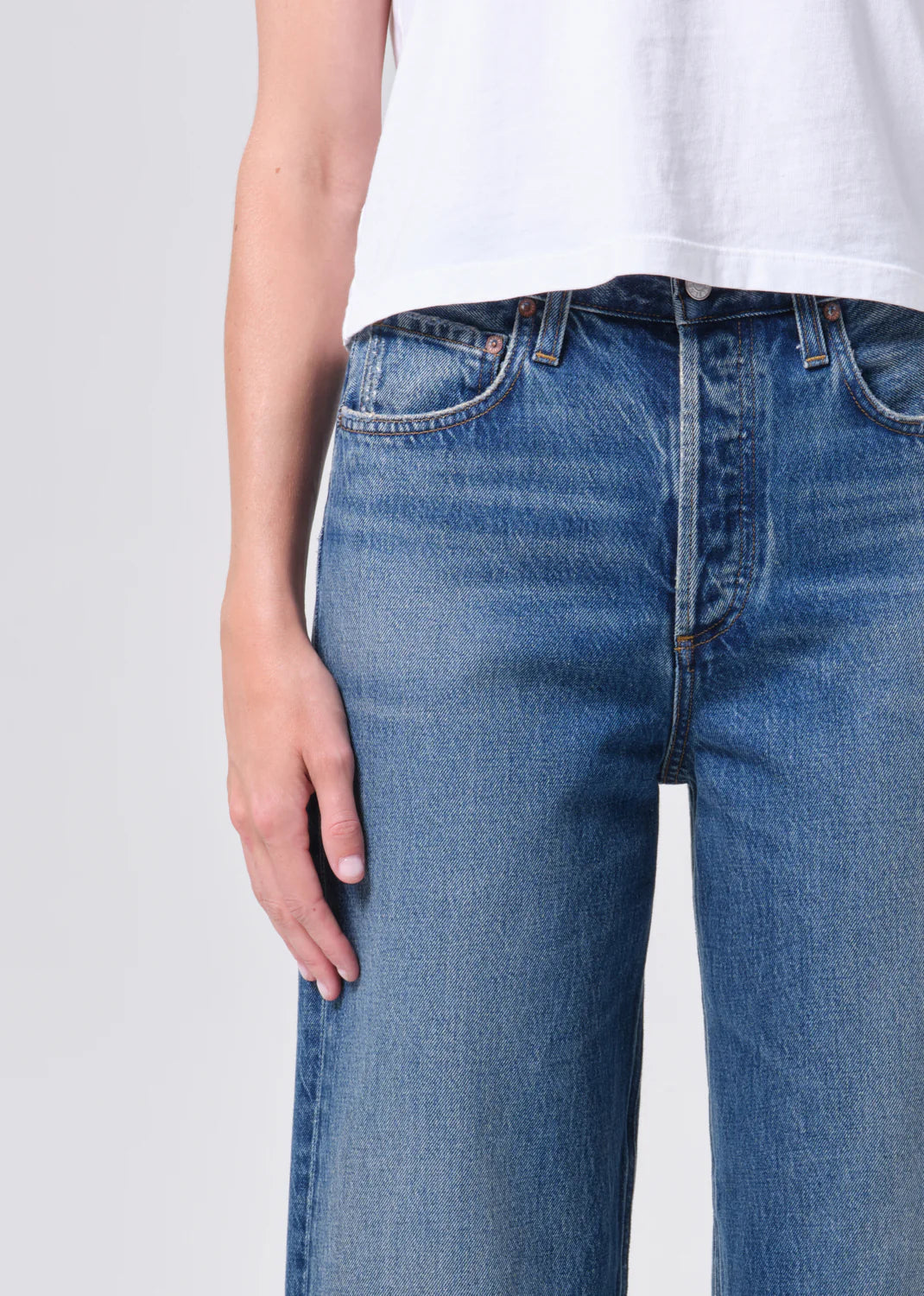 Close-up of woman wearing blue denim jeans and white top showcasing REN JEAN in chapter with a relaxed fit style