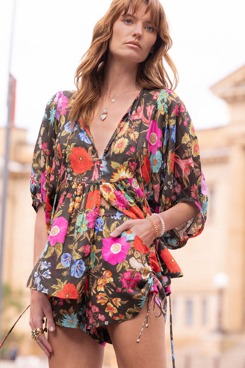 Woman wearing Valley of the Dolls Boho Blouse in vibrant floral print with billowy sleeves and relaxed fit