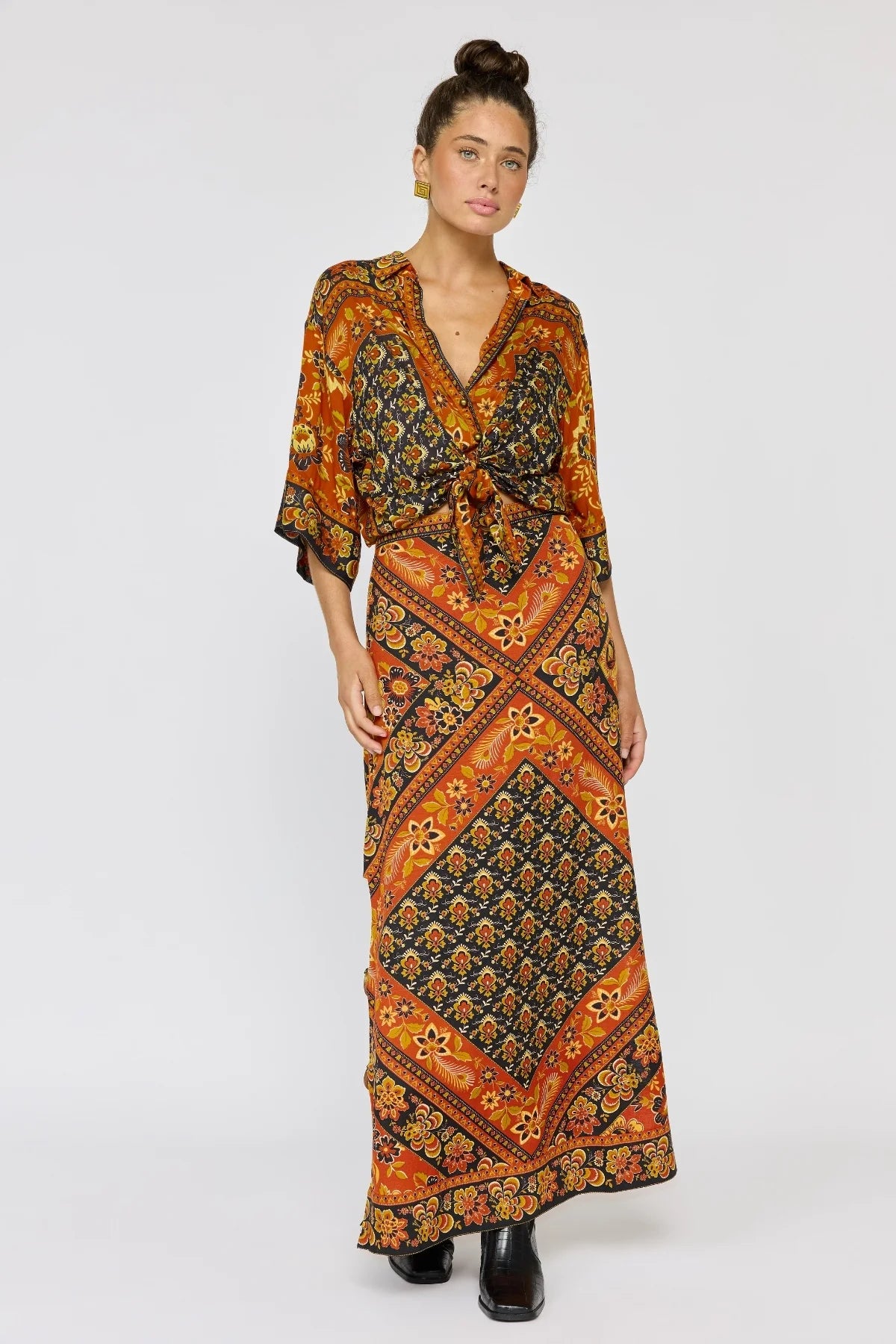 Woman wearing a patterned skirt and the Lois Shirt - Saffron with loose sleeves and warm autumn tones.
