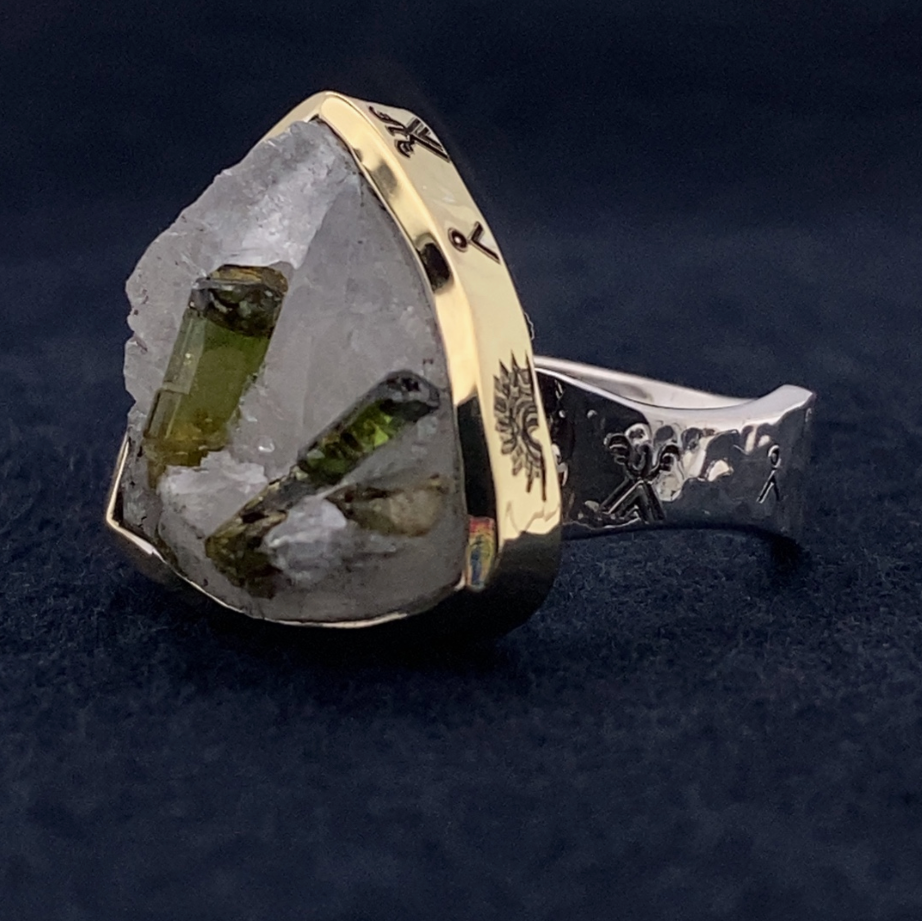 Ring with a large crystal stone and gold and silver band on a dark background
