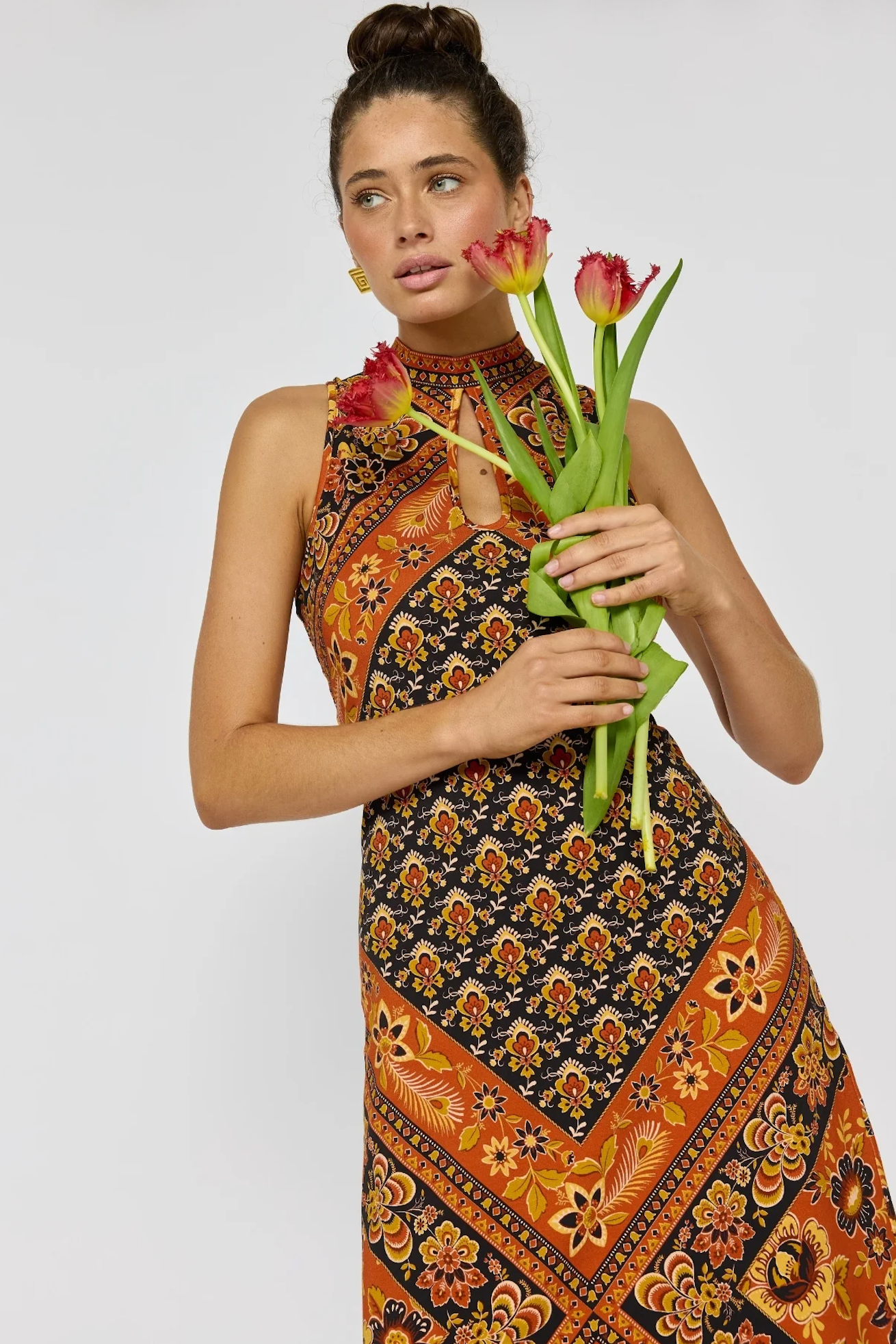 Woman holding tulips wearing Sydney Midi Dress in Saffron with vibrant bohemian floral pattern and keyhole neckline