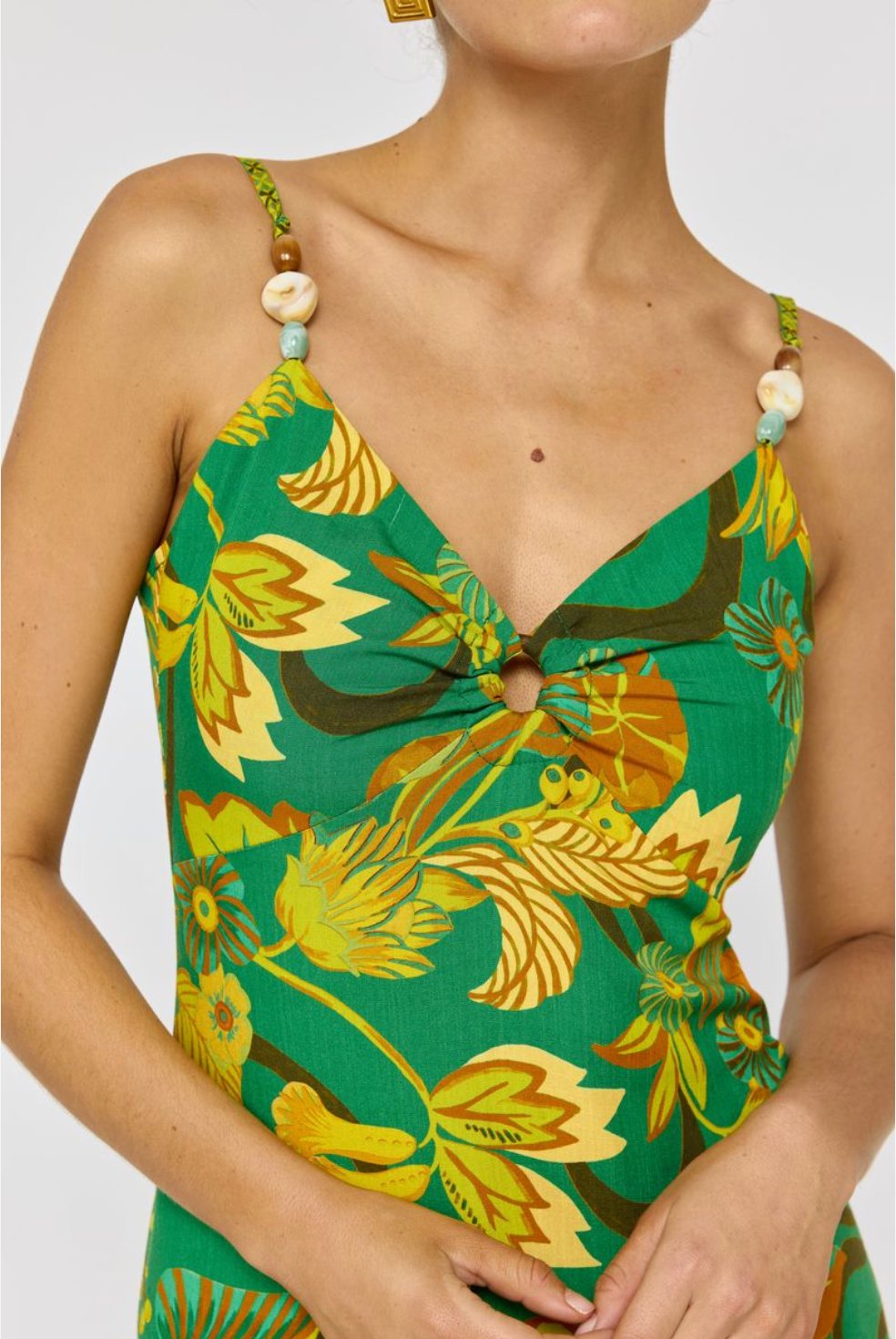 Close-up of a vibrant Martini Midi Dress in Absinthe with bold floral prints and decorative bead straps.