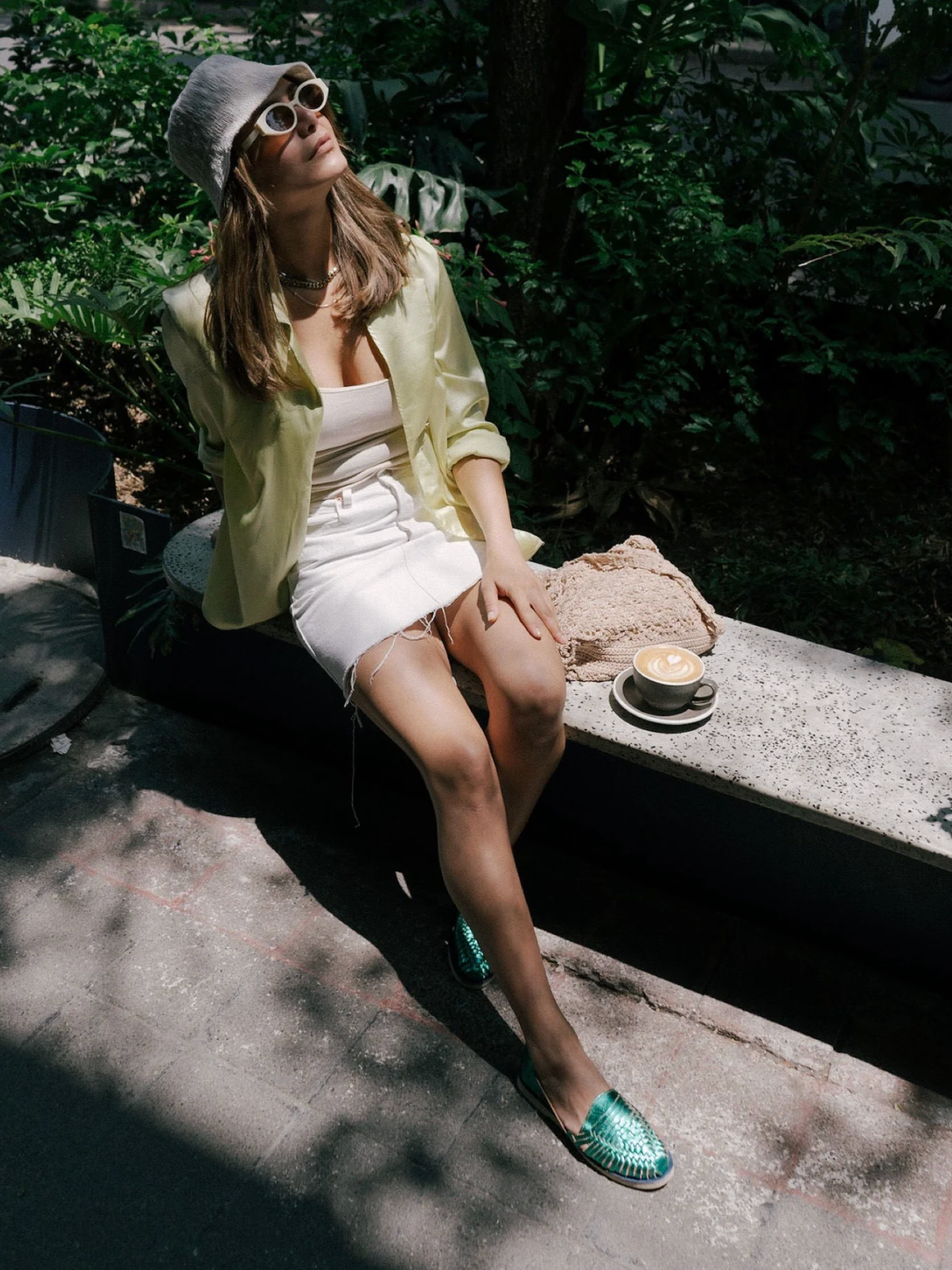 Woman wearing Emerald Slip On Huaraches in a sunny garden setting, paired with casual chic summer outfit and accessories.