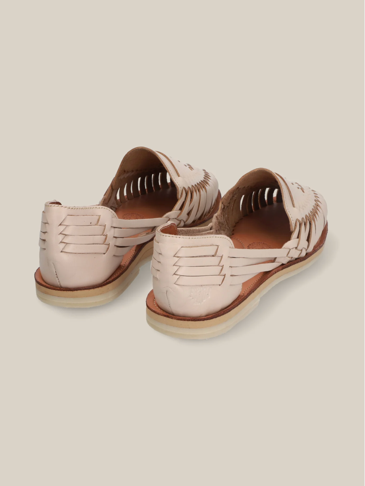 Pair of light beige leather Desierto Classic Huaraches sandals with woven detailing and flat soles on neutral background