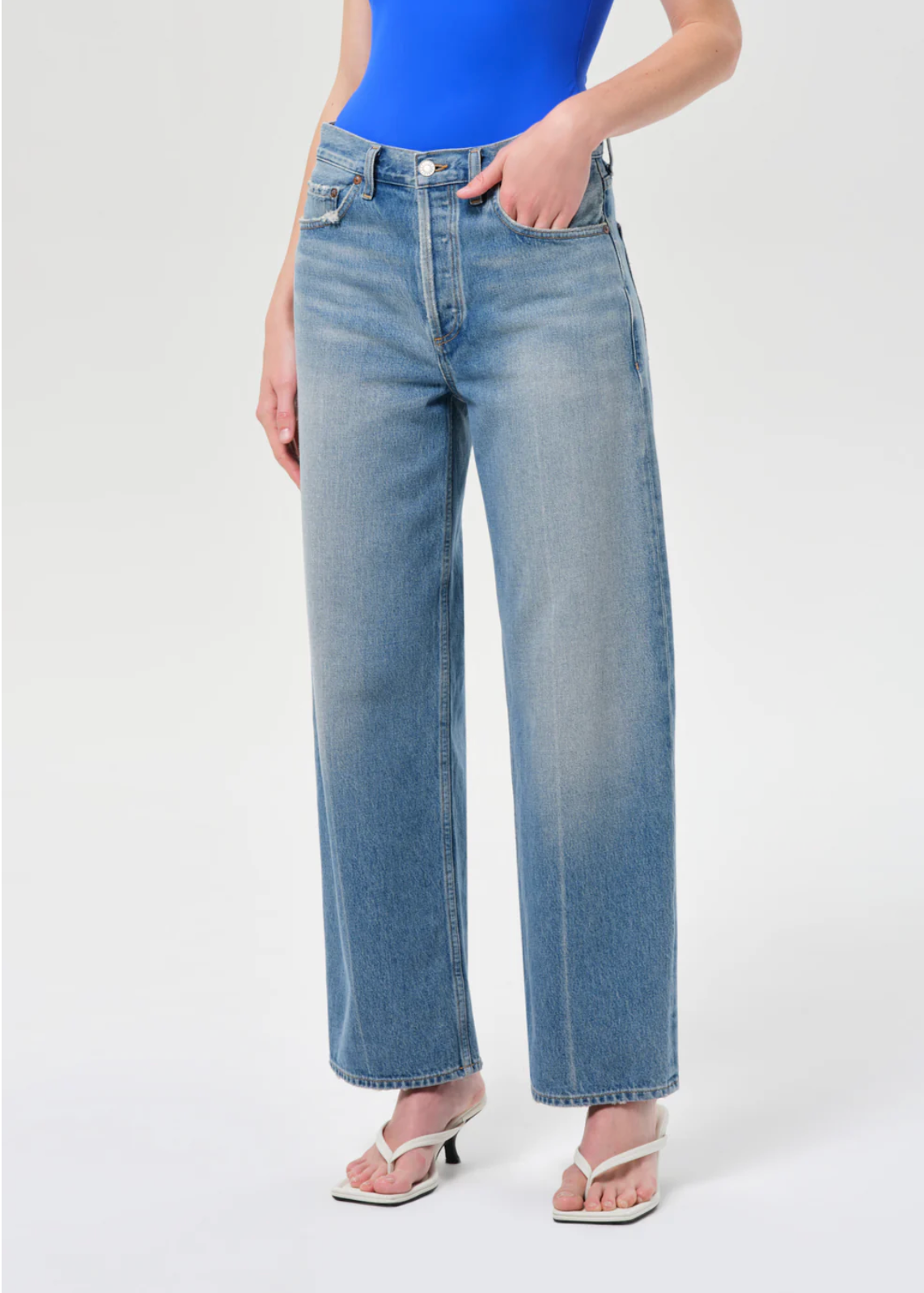 Model wearing light wash denim Arc Jean 29" In Brink by Agolde" with relaxed straight-leg fit and high waist styling.