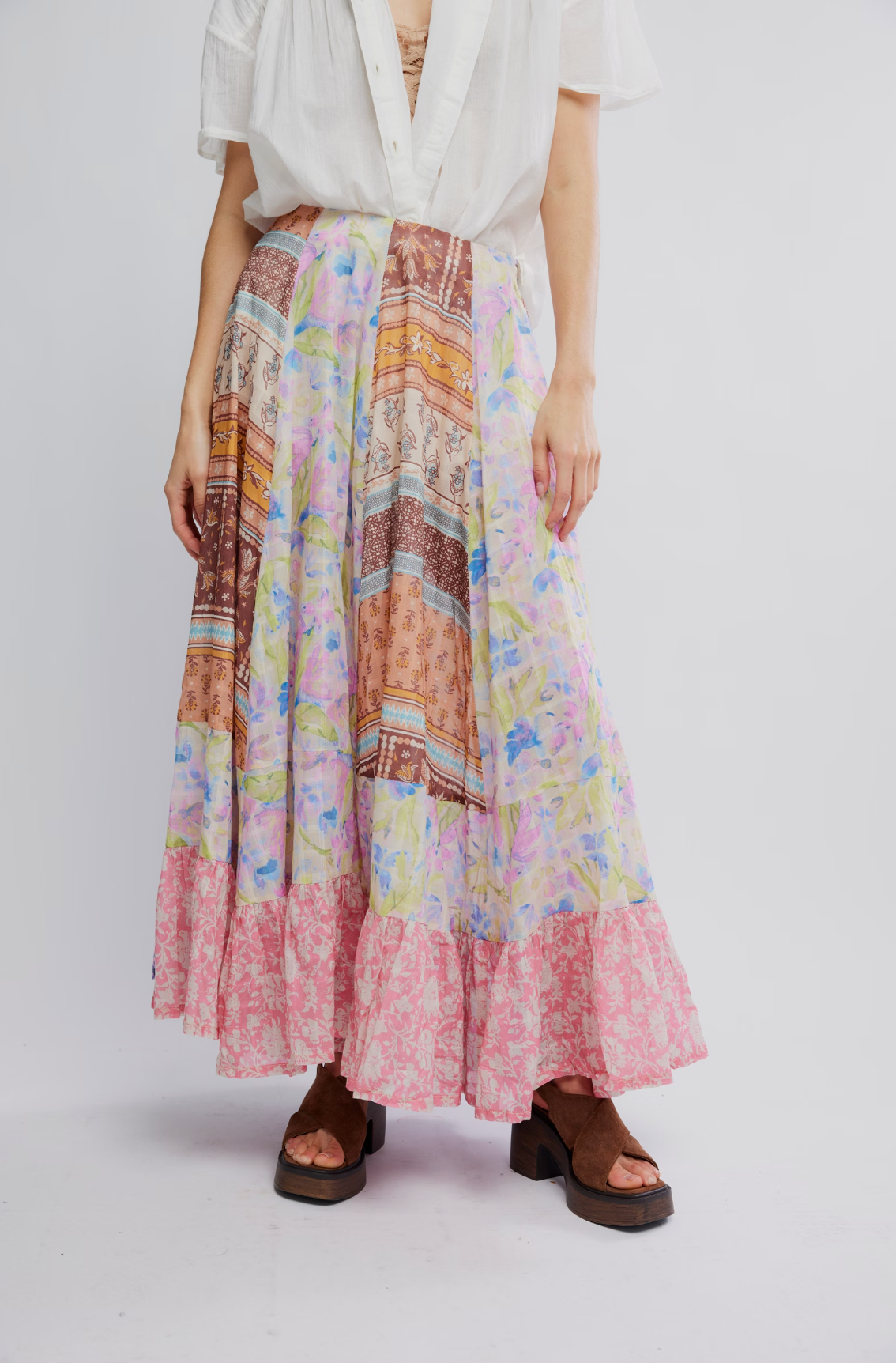 Woman wearing Santa Eulalia Printed Maxi Skirt by Free People with floral and patchwork patterns and brown platform sandals.