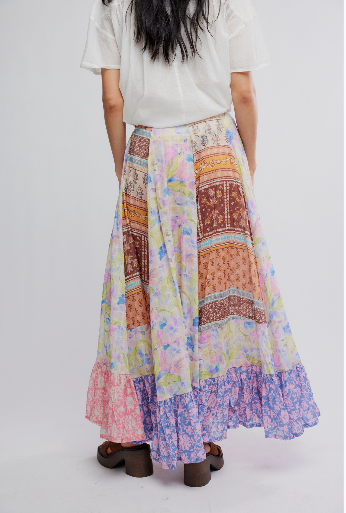 Woman wearing a colorful flowy Santa Eulalia Printed Maxi Skirt by Free People with floral and patchwork patterns