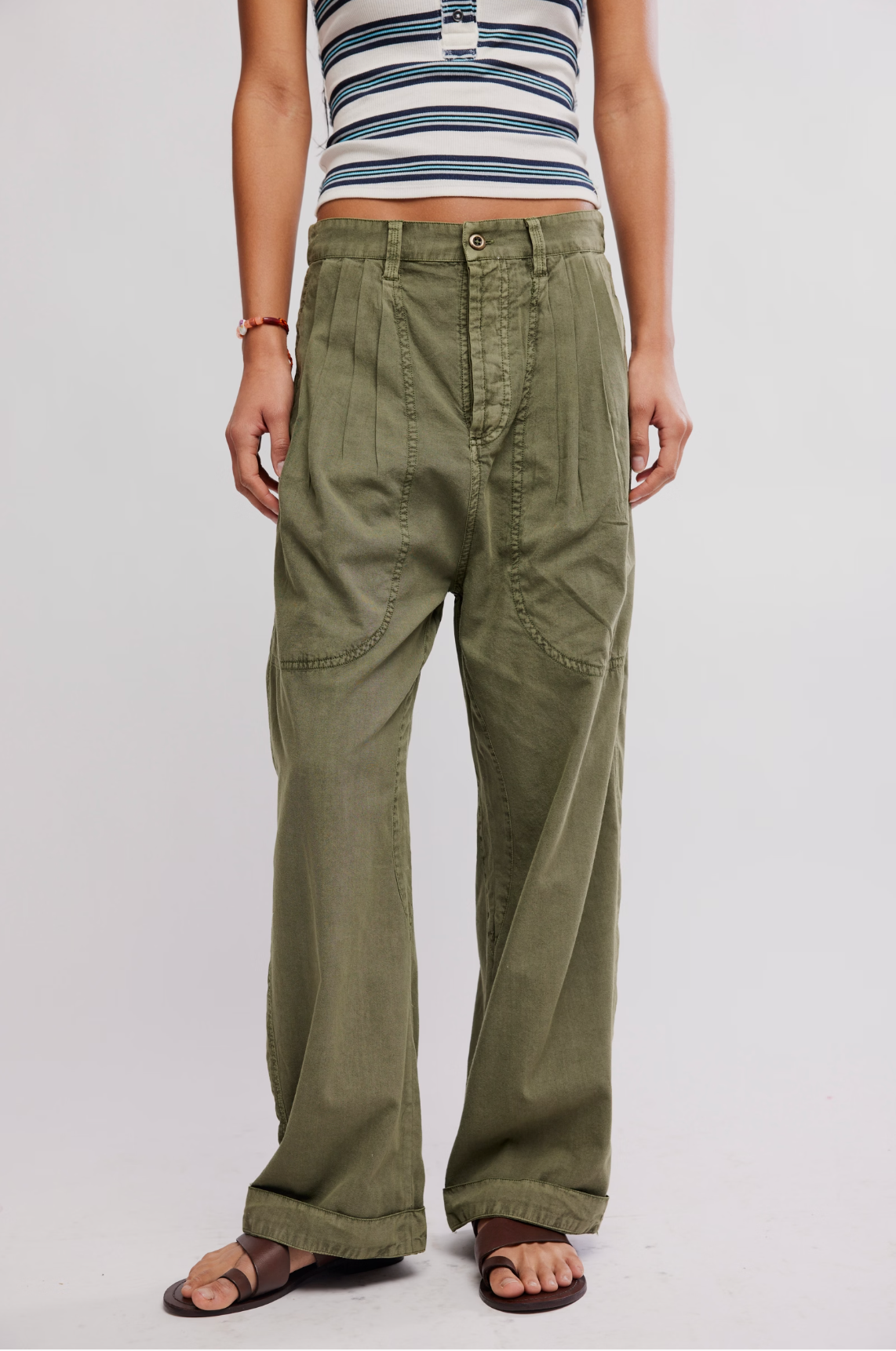 Front view of olive green casual wide-leg pants, Clover Dropped Trouser by Free People, styled with sandals and striped top.