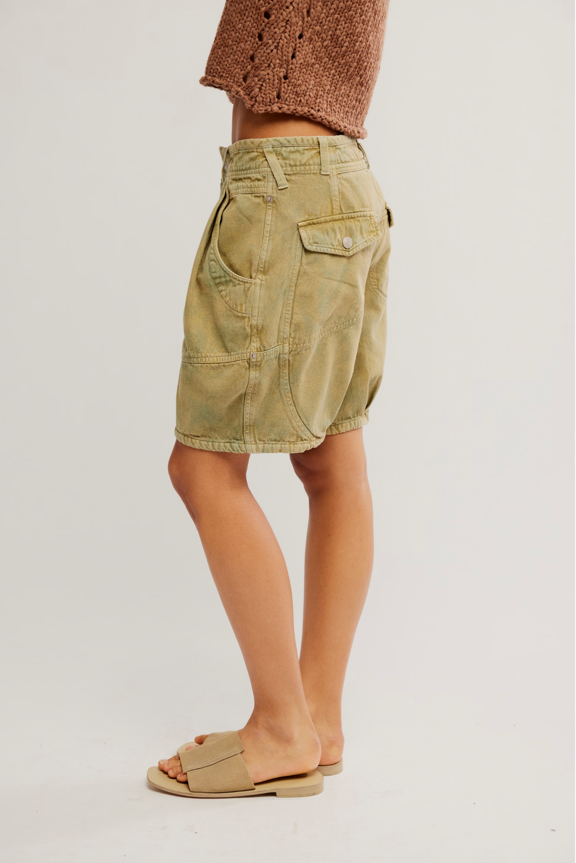Side view of a model wearing Wild Rebel Short in Outlaw Taupe with casual beige sandals and a cropped knitted top.