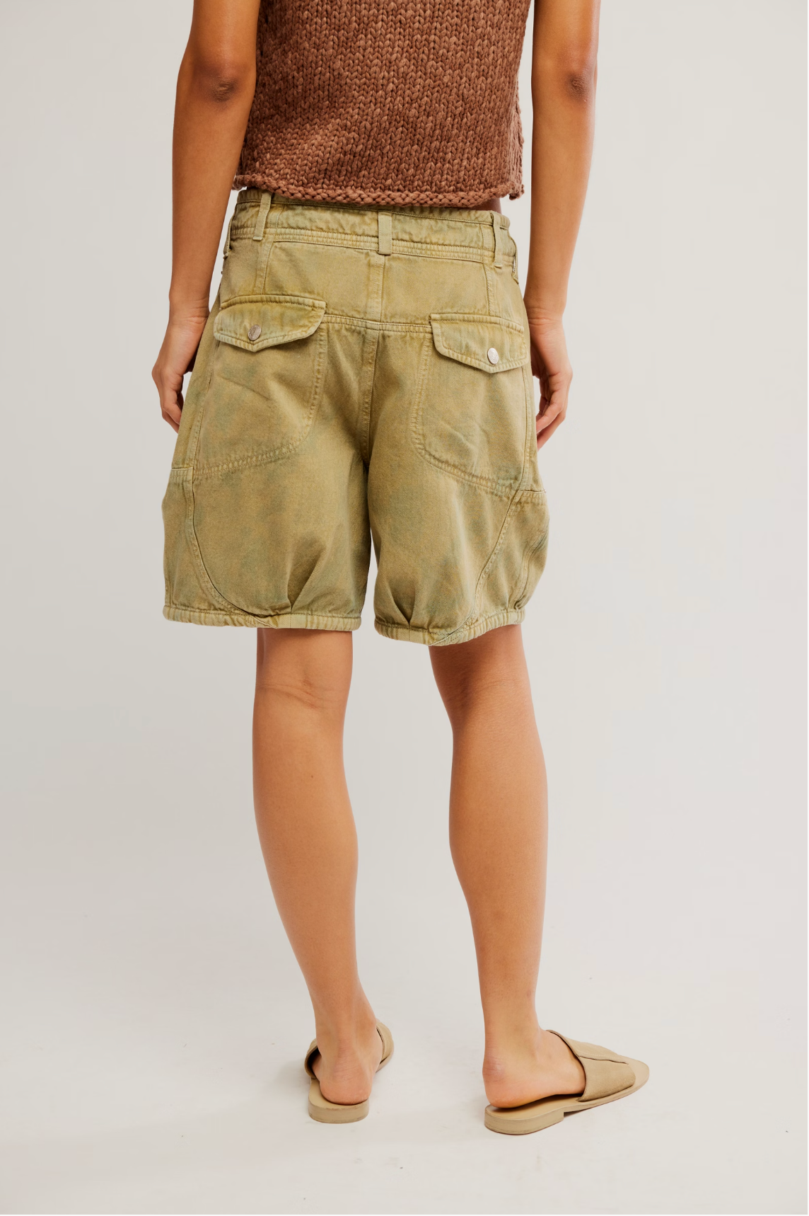 Back view of a person wearing Wild Rebel Short in Outlaw Taupe with buttoned flap pockets and elastic hems.
