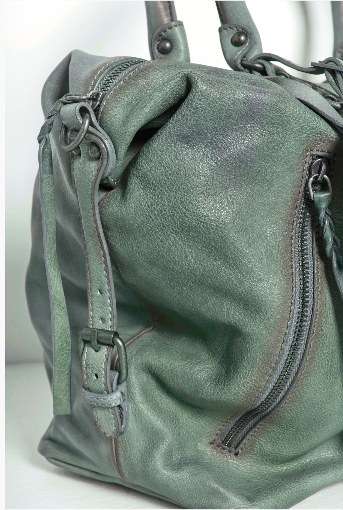 We The Free Emerson Tote Bag in Secret Sage showcasing textured leather, zipper pocket, and buckle strap detail close-up