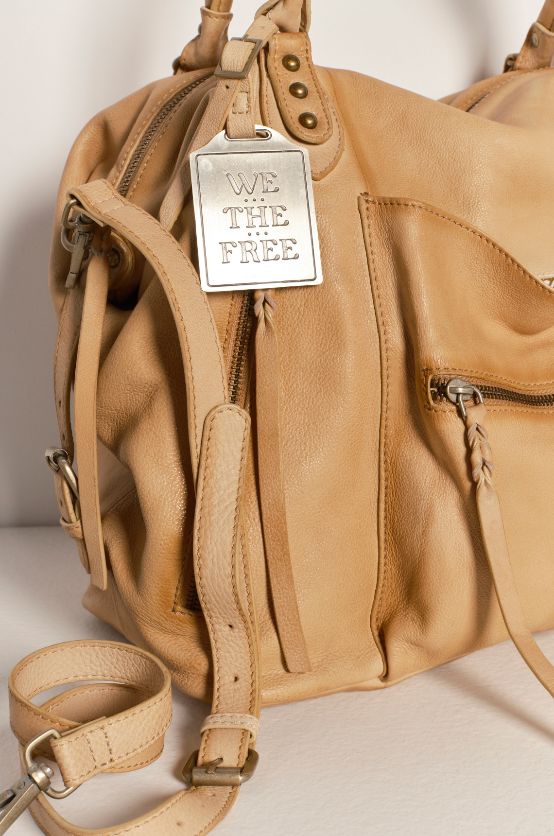 We The Free Emerson Tote Bag in Italian Straw featuring soft leather, brass hardware, and a branded metal tag detail