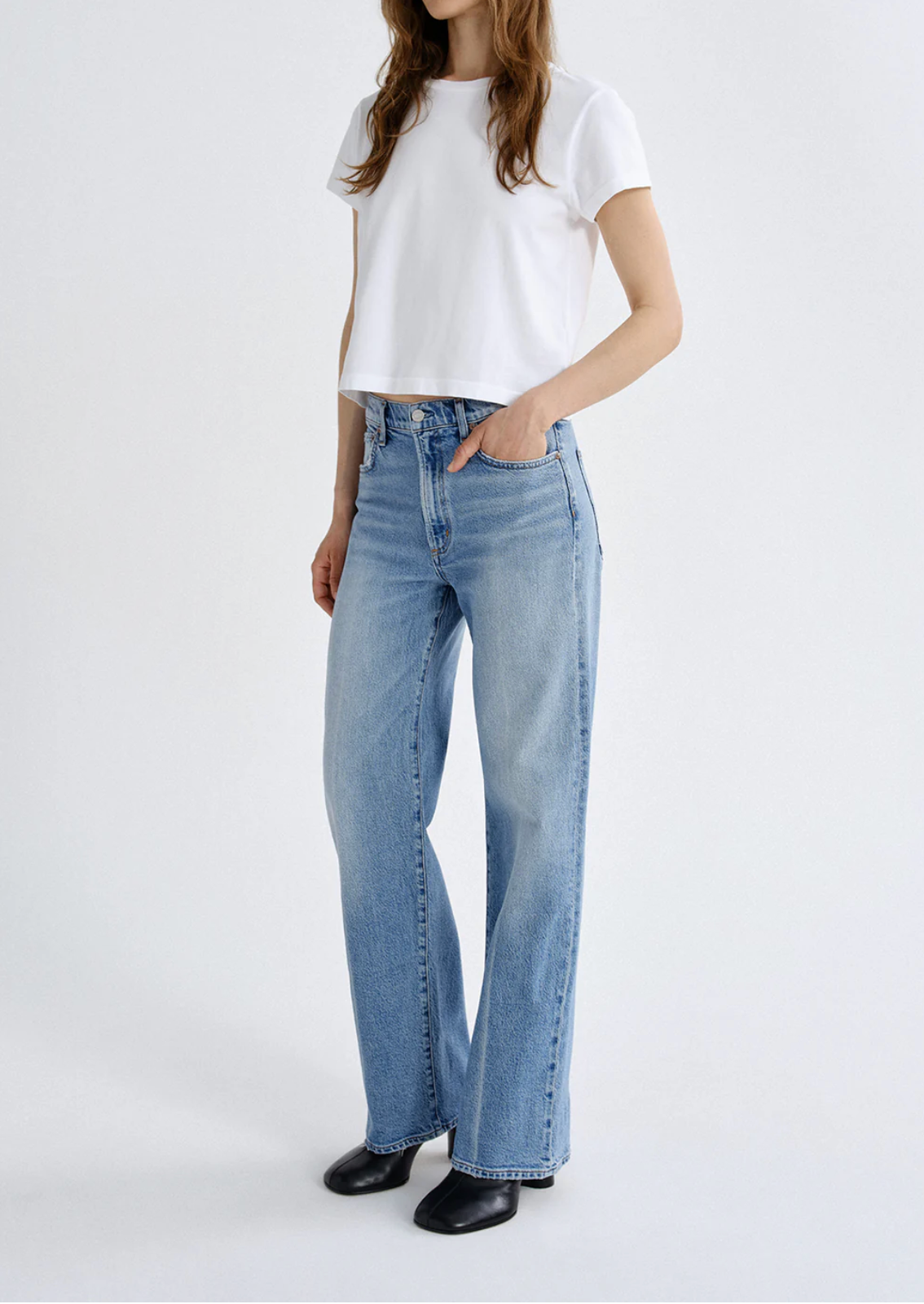 Model wearing The Harper Jean in Outlook by Agolde, light blue high-rise wide-leg denim styled with a white cropped tee.