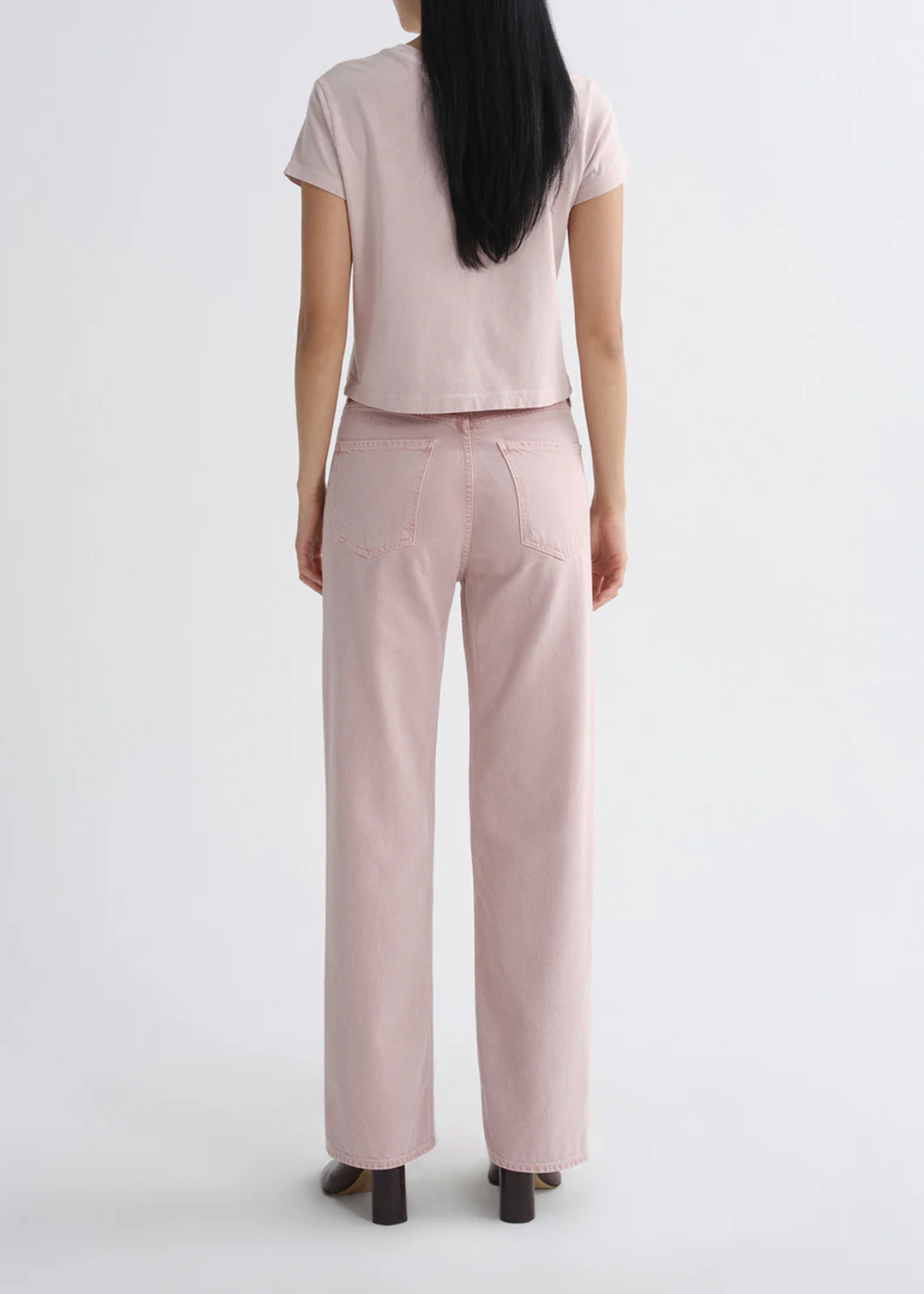 Woman wearing The Adine Shrunken Te in Wallflower by AGOLDE, soft pink high-rise straight leg jeans from the back view.