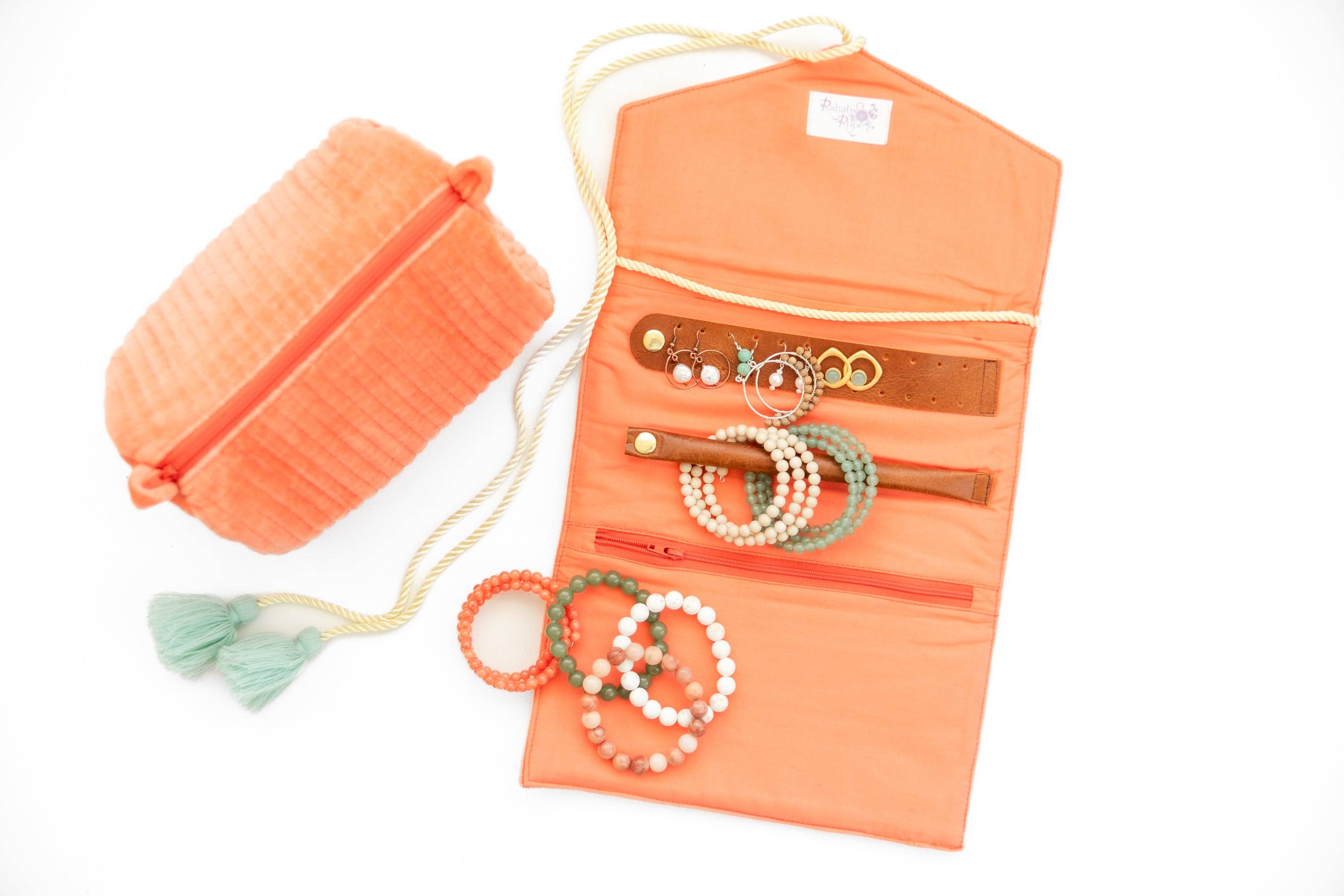 Embroidered Velvet Jewelry Organizer-Coral holding bracelets, rings, and earrings with tassel drawstring pouch nearby