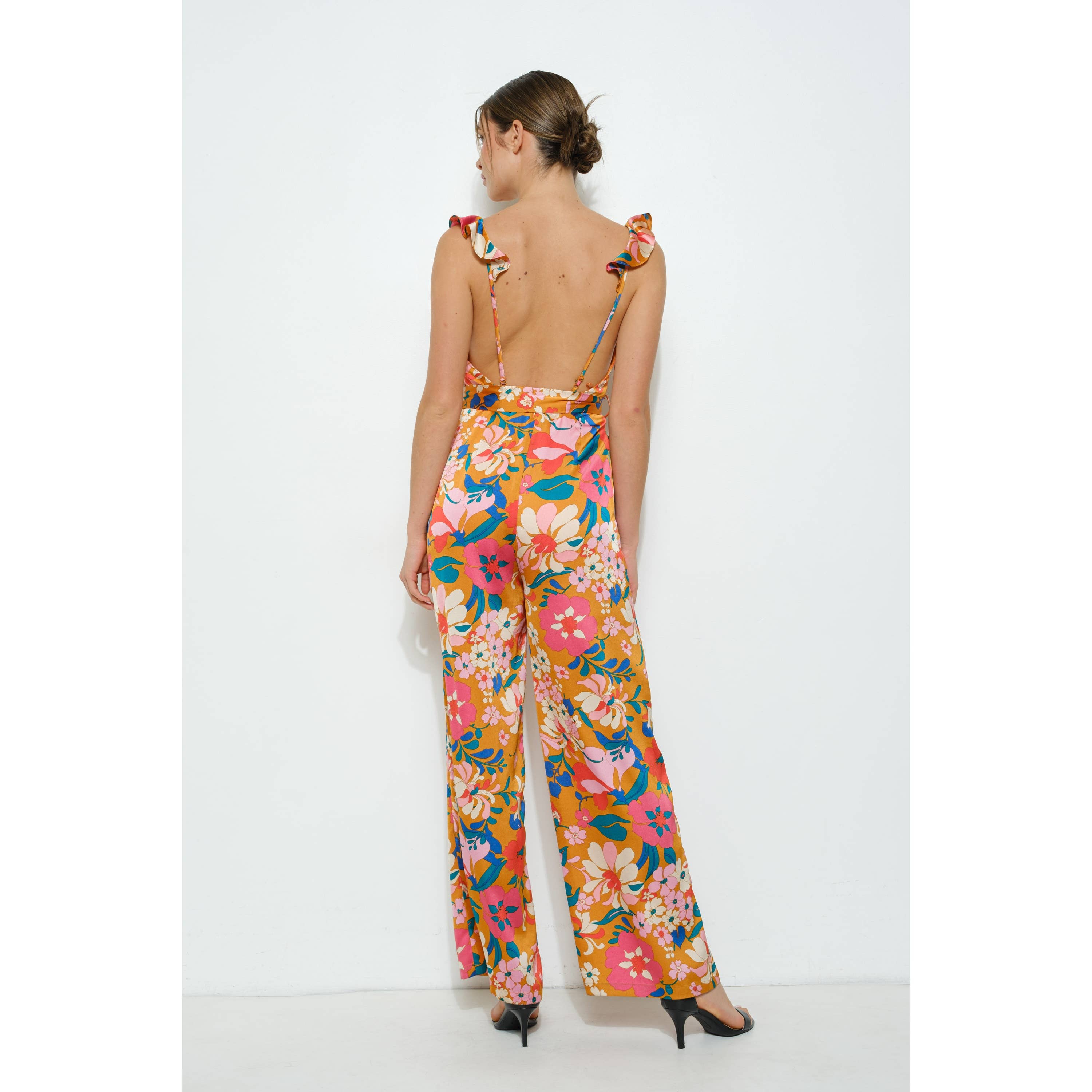 Woman wearing a colorful floral jumpsuit on a white background