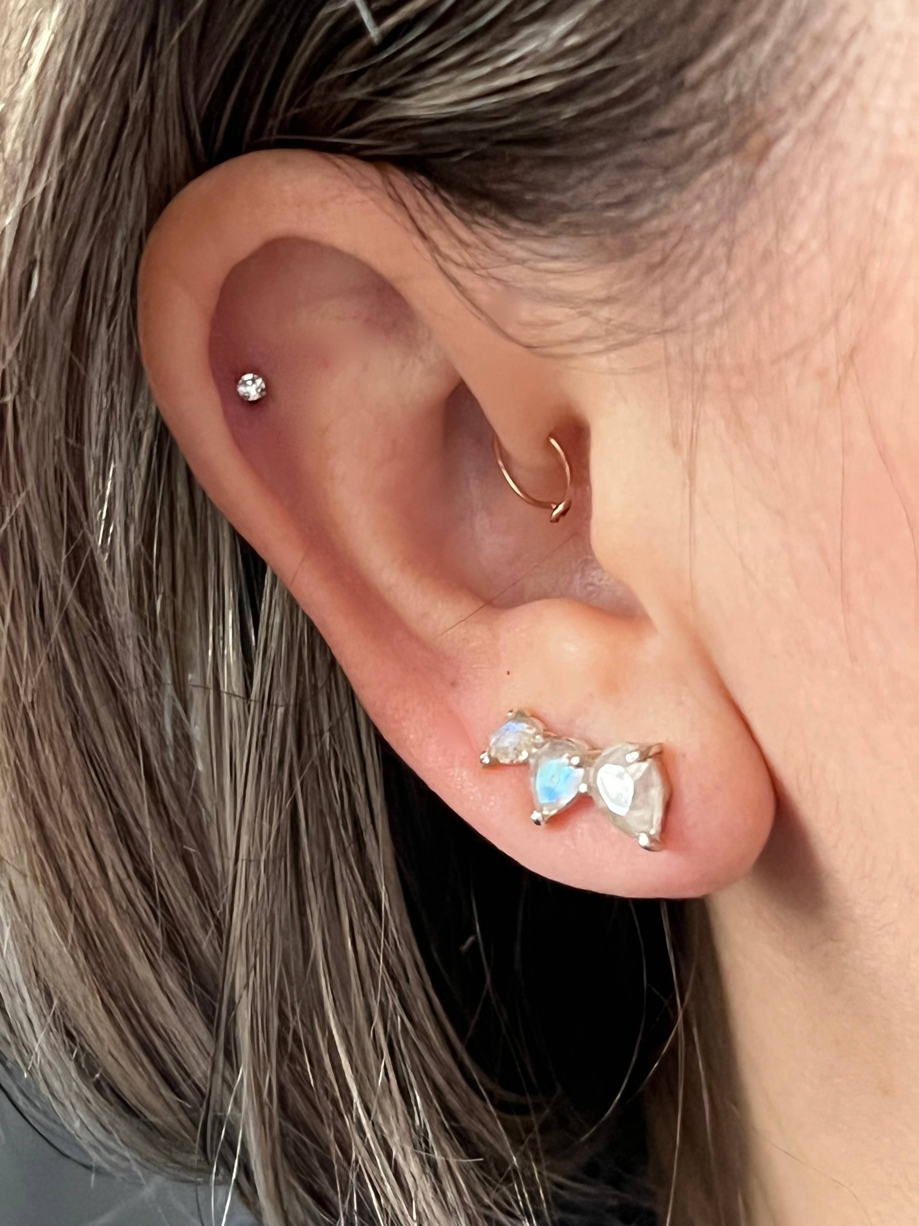 Stacked Tear Drop Ear Climber with Faceted Moonstone worn on ear, featuring delicate iridescent stones in silver setting