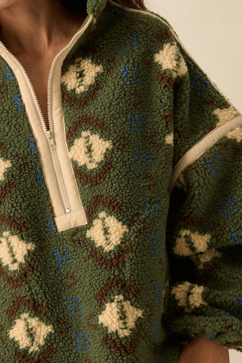 A person is wearing the Promesa USA Geo-Print Sherpa Fleece Half-Zip Pullover Jacket in green with cream and brown patterns; only the torso and part of the face are visible.