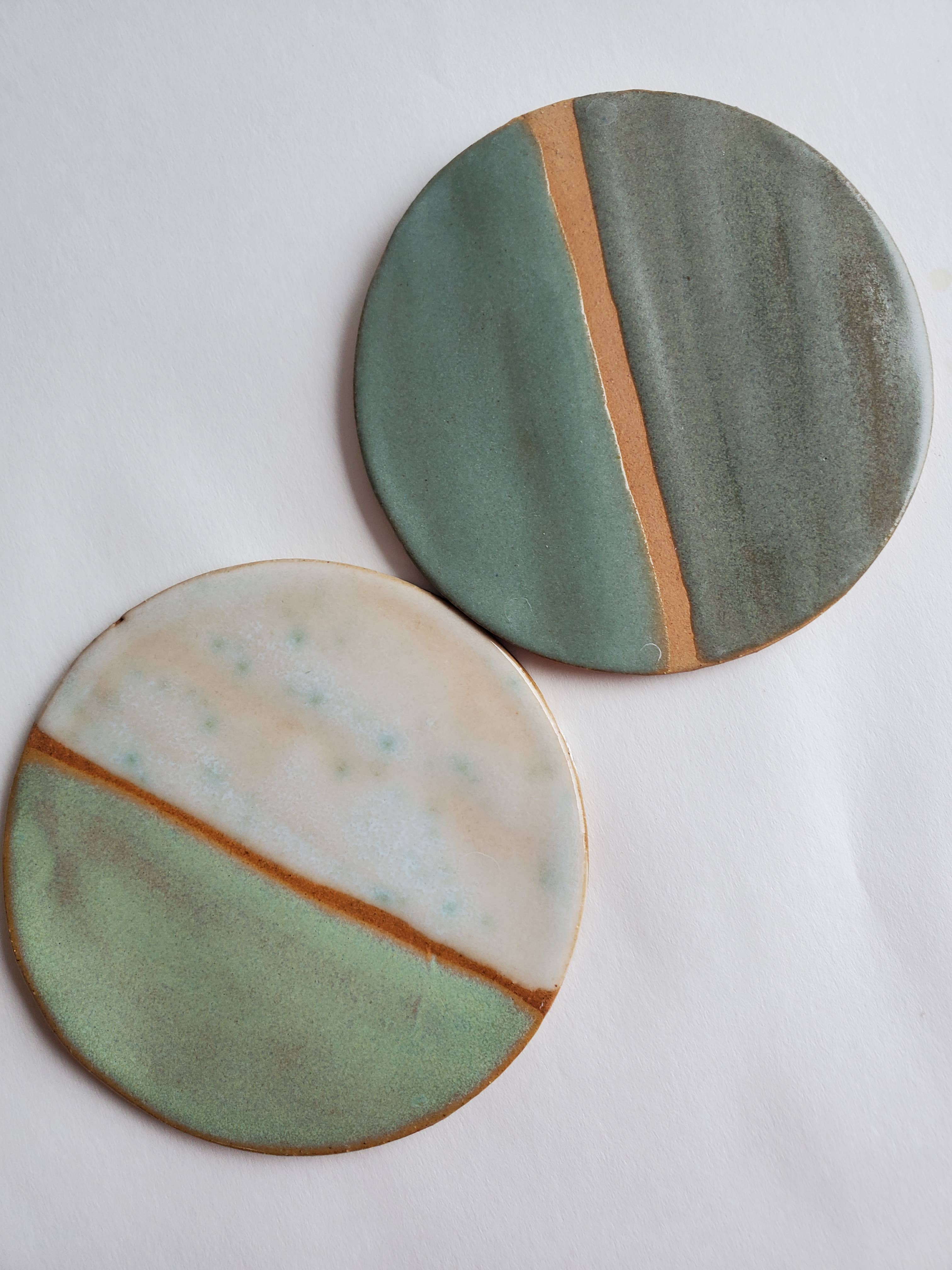 Monstera leaf ornament featuring two round ceramic pieces with abstract green, beige, and brown color blocking design