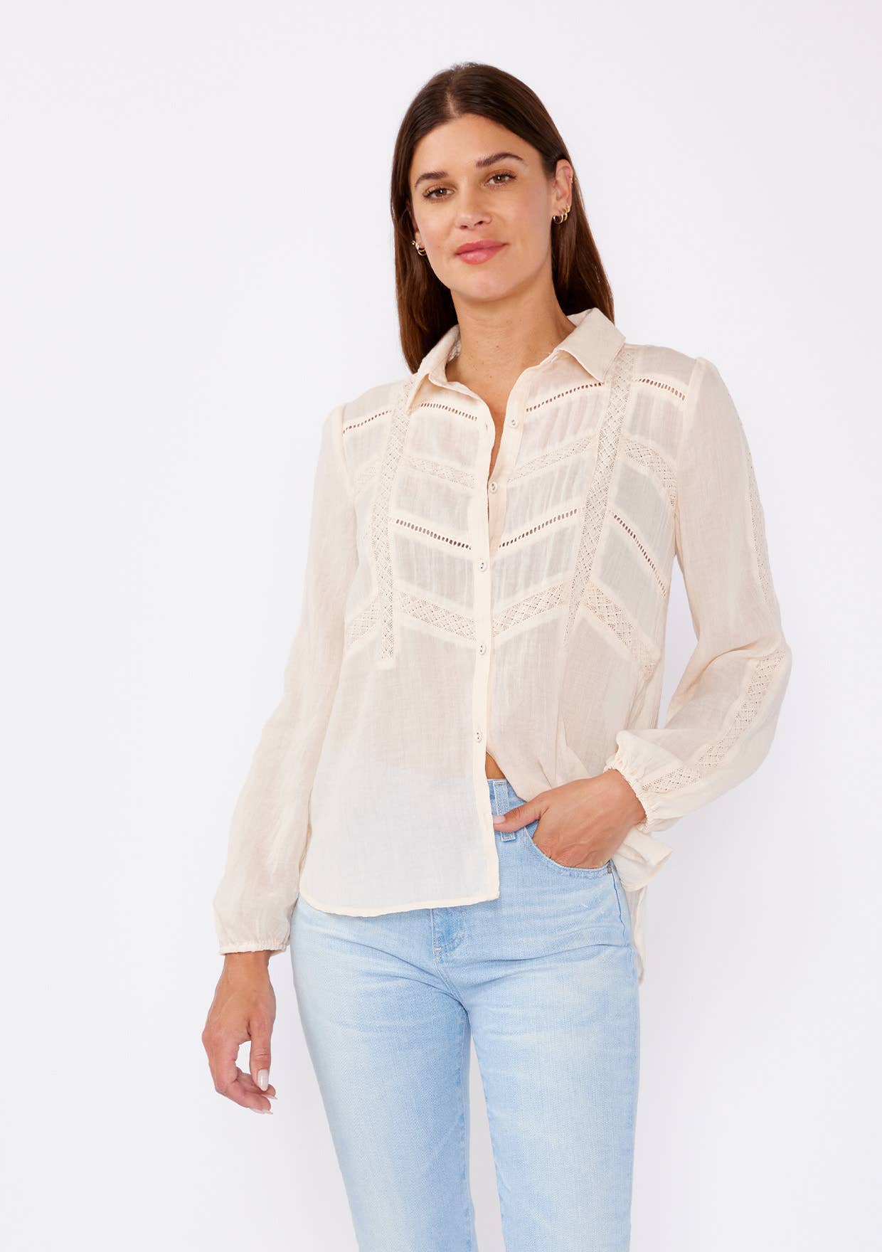 Woman wearing a light beige Crinkled Lace Long Sleeve Button Down Blouse with delicate lace details and light blue jeans
