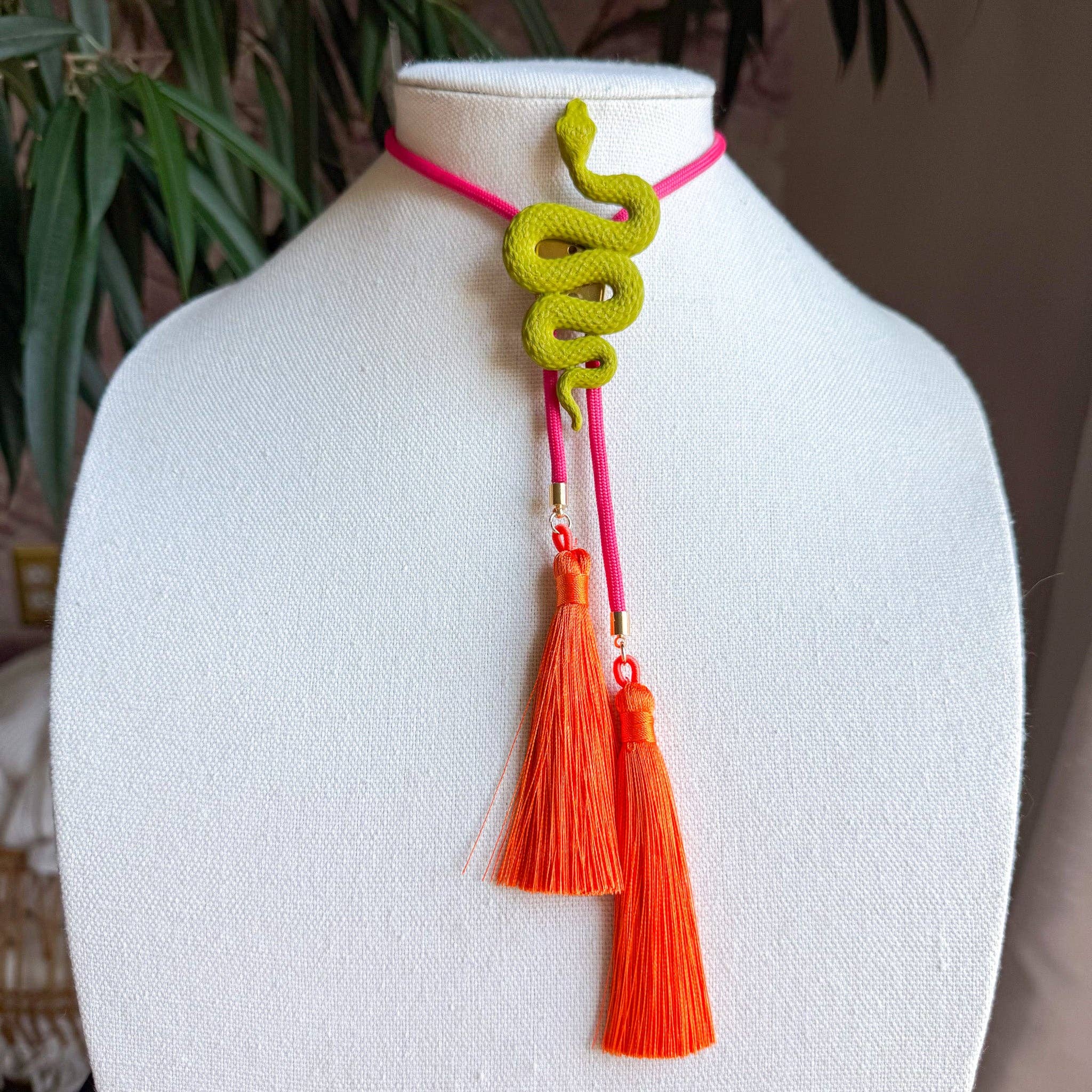 Snake Bolo Olive Green with Fuchsia & Orange featuring a coiled snake pendant and bright orange tassels on display bust
