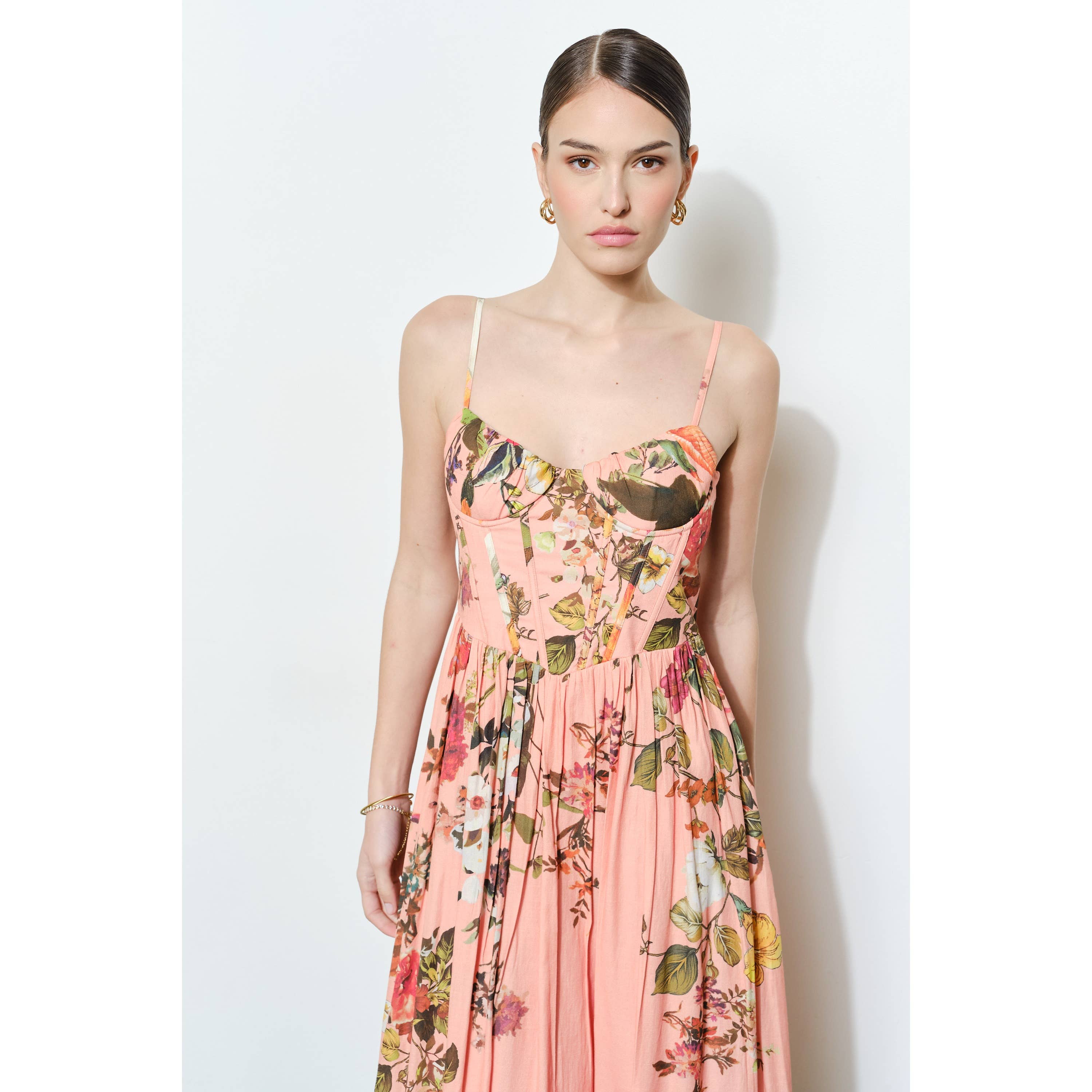 Woman wearing a Vintage Floral Sweetheart Maxi Dress with soft pink fabric and colorful floral patterns against a white background