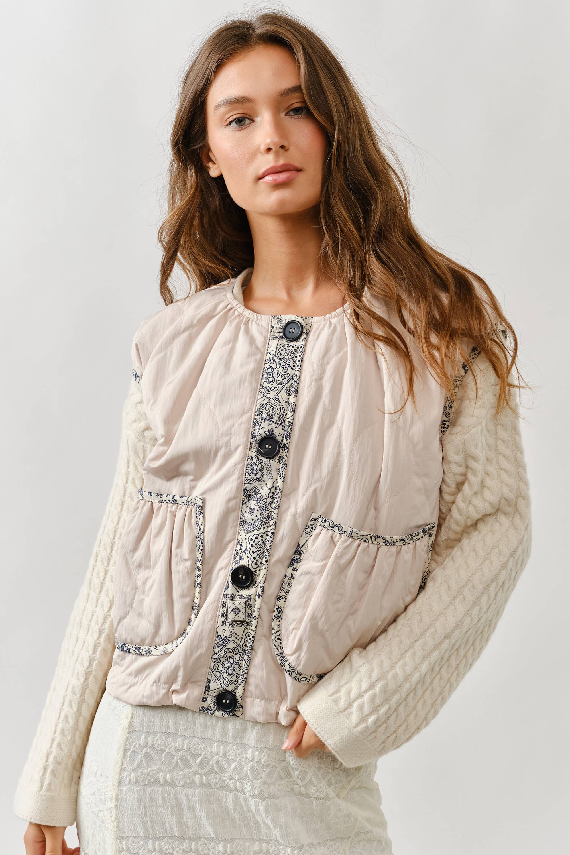 A woman with long brown hair wears the Aaron & Amber Contrast Detail Lightweight Vest, featuring cap sleeves, patterned trim, and large buttons. She stands confidently against a plain light background, facing the camera.