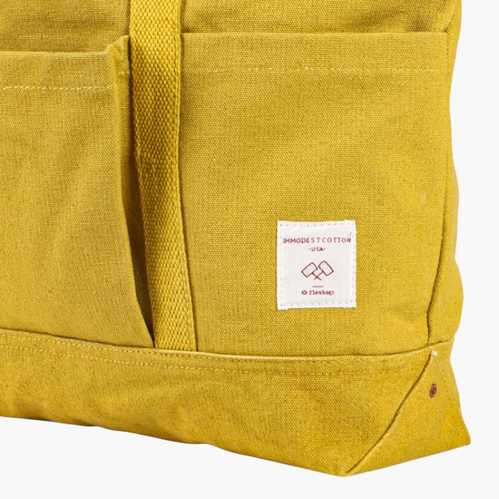 Close-up of durable fabric detail and label on the vibrant Construction Tote | Chartreuse bag with front pocket