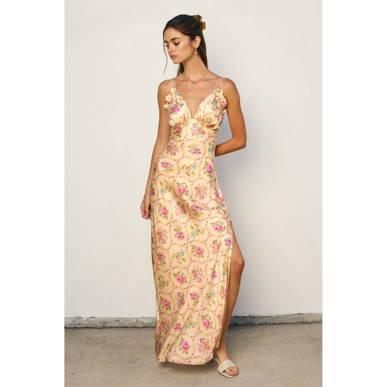 Woman in a pastel floral Eternal Afternoon Ruffled Triangle Bust Maxi Dress with side slit and delicate ruffle details.