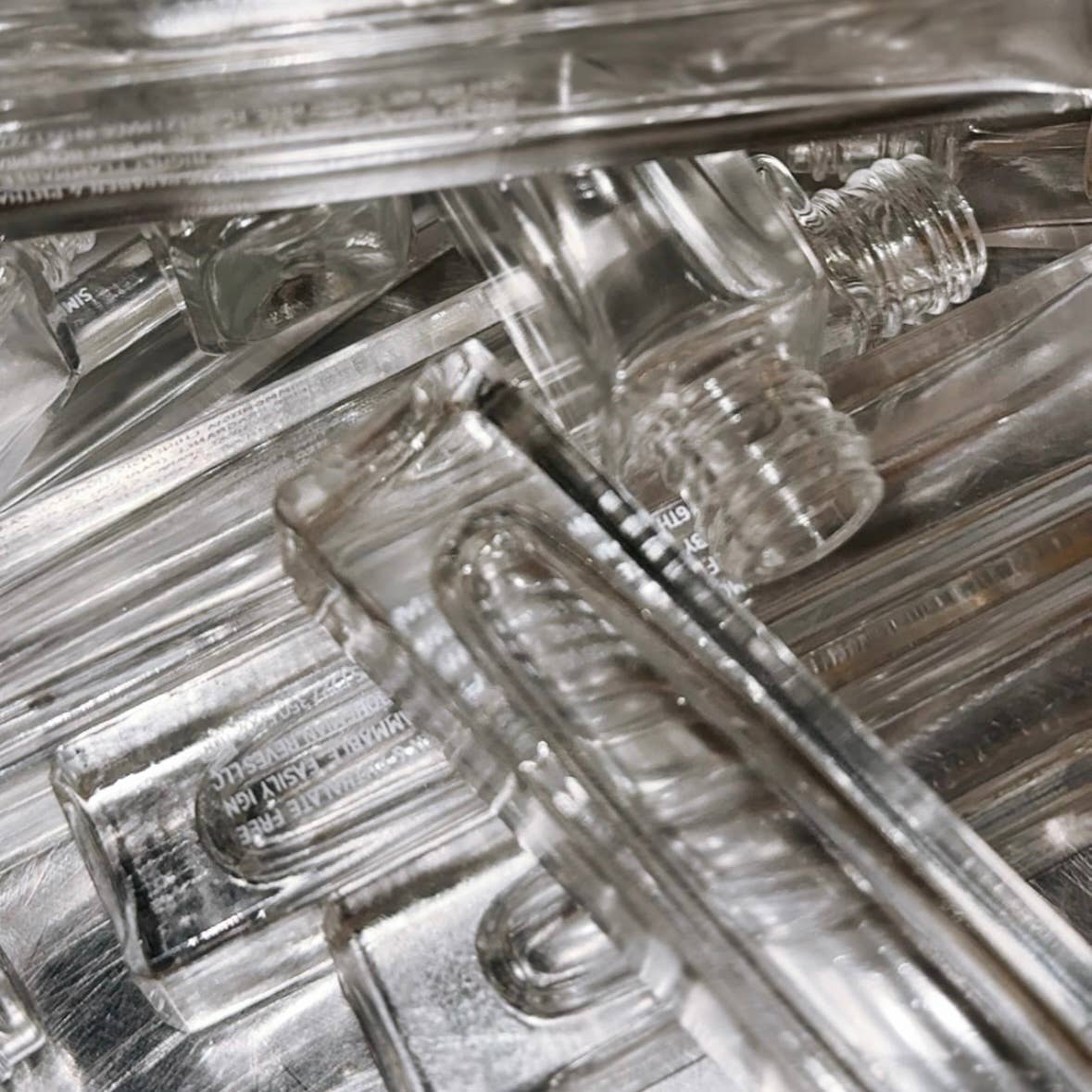 Clear empty glass rollerball perfume bottles stacked closely, Desert Fleur Botanical Perfume Rollerball 10mL | Earthy & Iconic.