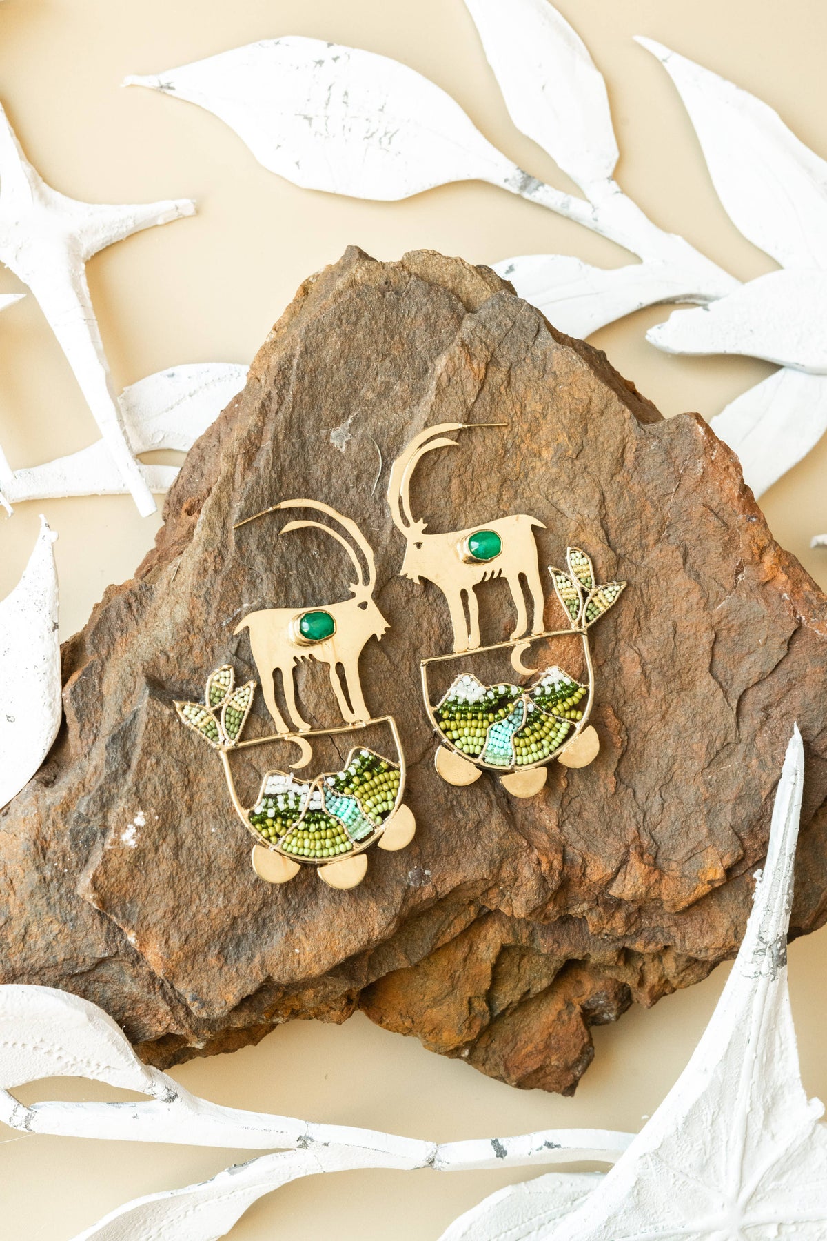 Wild Highland Hoops artisan elephant earrings with colorful beaded details on textured wood