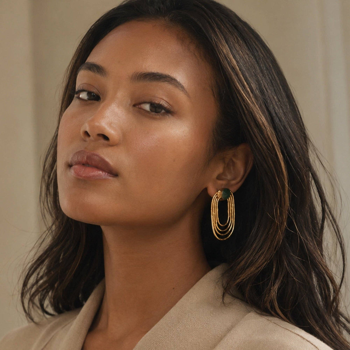 Jude Emerald Oval Earrings featuring elegant layered gold oval hoops worn by a model