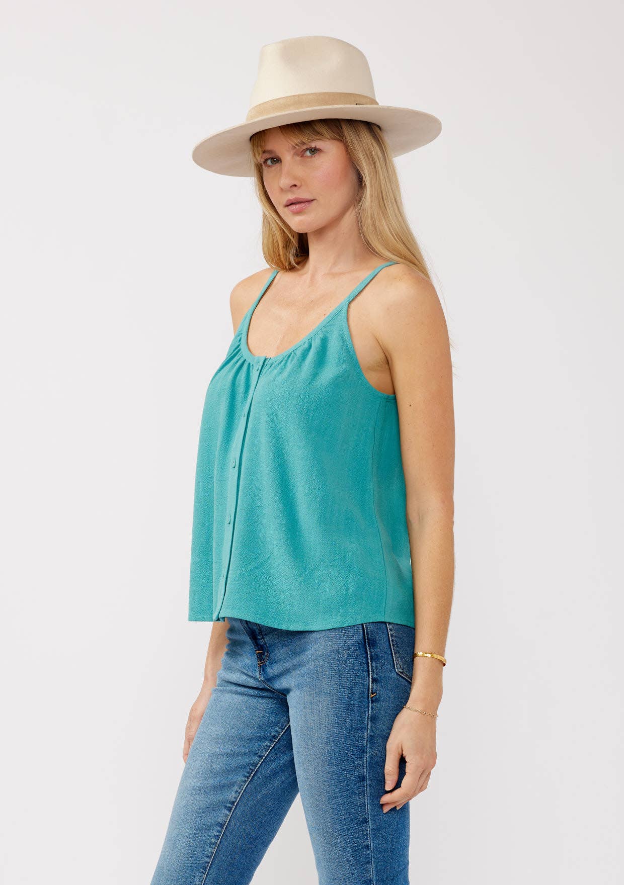 Woman wearing turquoise Scoop Neck Button-Down Cami with jeans and beige wide-brimmed hat in studio setting