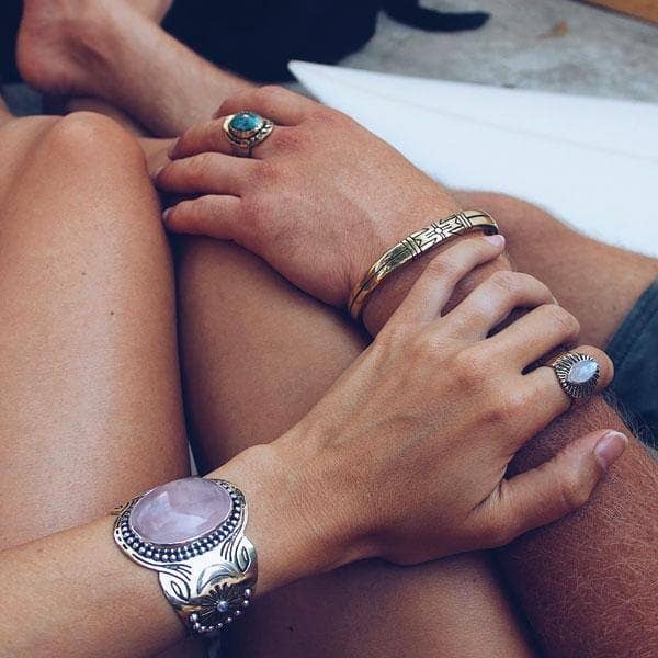 Close-up of hands wearing Medicine Wheel Cuff || Men and artisan rings, showcasing detailed metalwork and natural stones.
