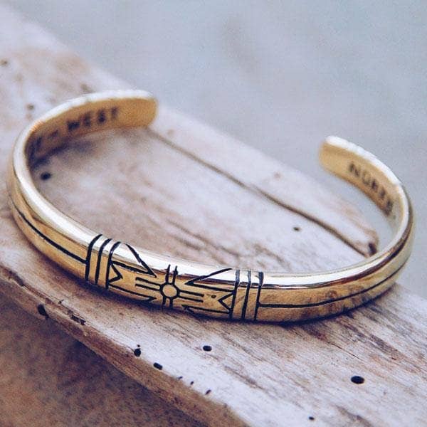 Elegant gold cuff bracelet featuring engraved Medicine Wheel design, named Medicine Wheel Cuff || Men, with directional markings.