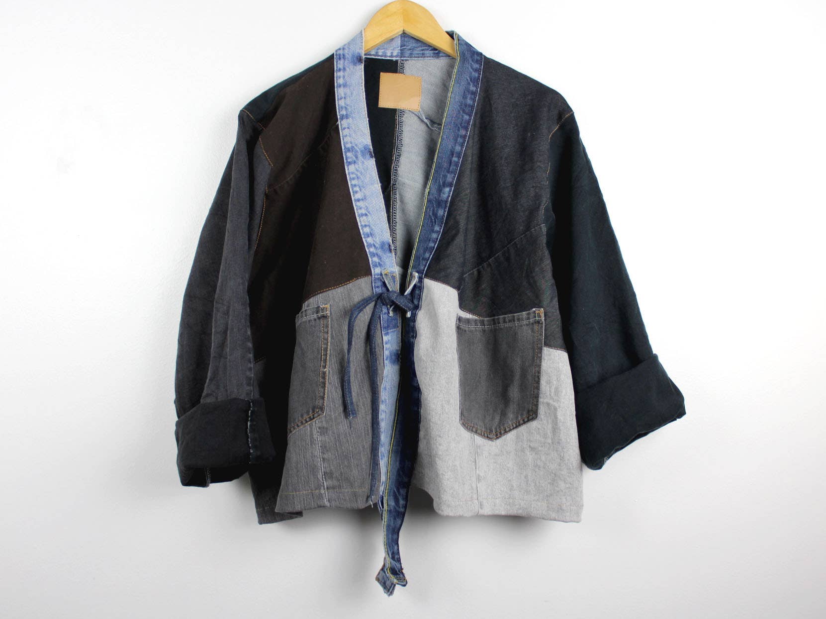 Upcycled Patchwork Denim Jacket with mixed denim shades, large pockets, and relaxed open front with tie closure