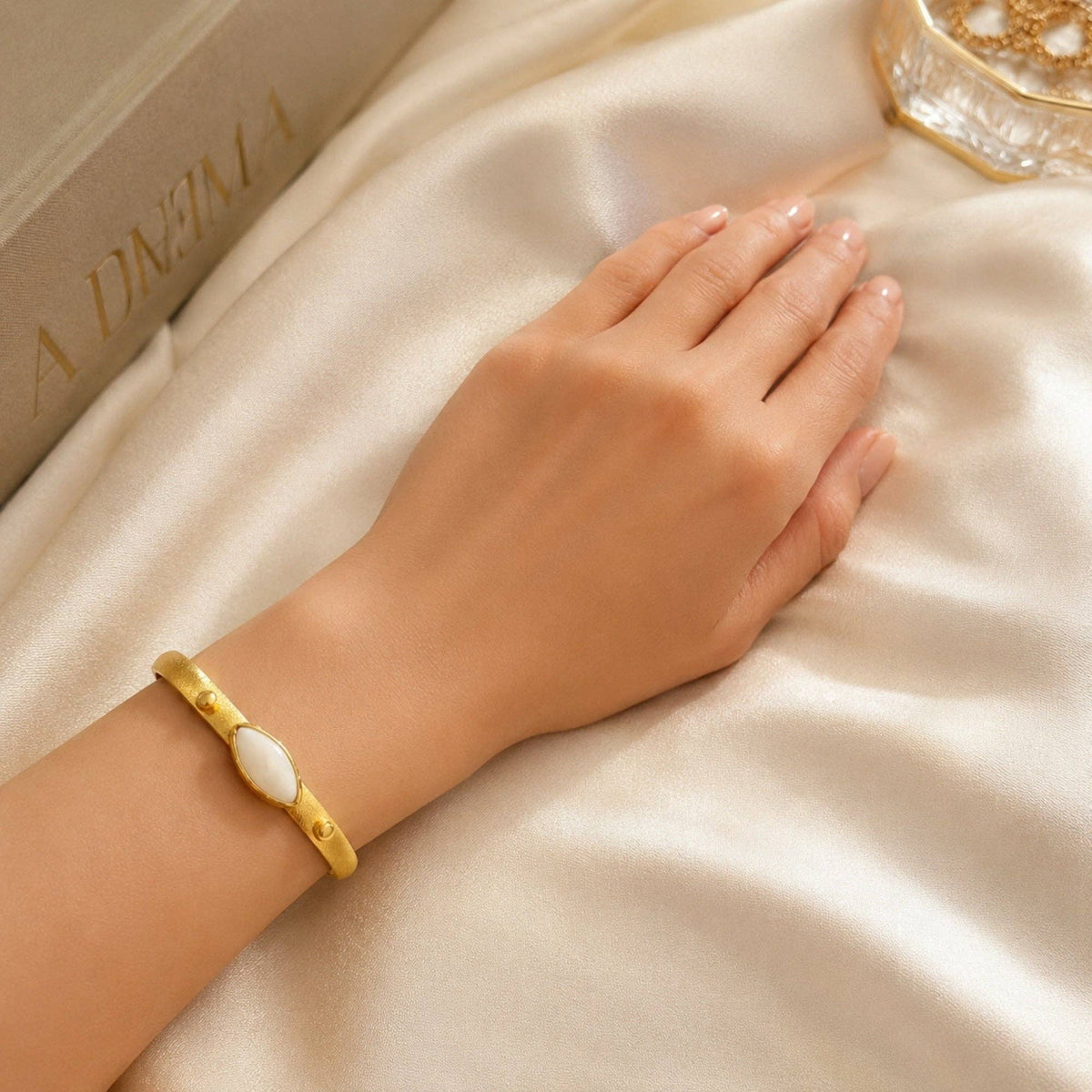 Zeynab Mother of Pearl Cuff Bracelet on wrist with gold finish and oval mother of pearl detail