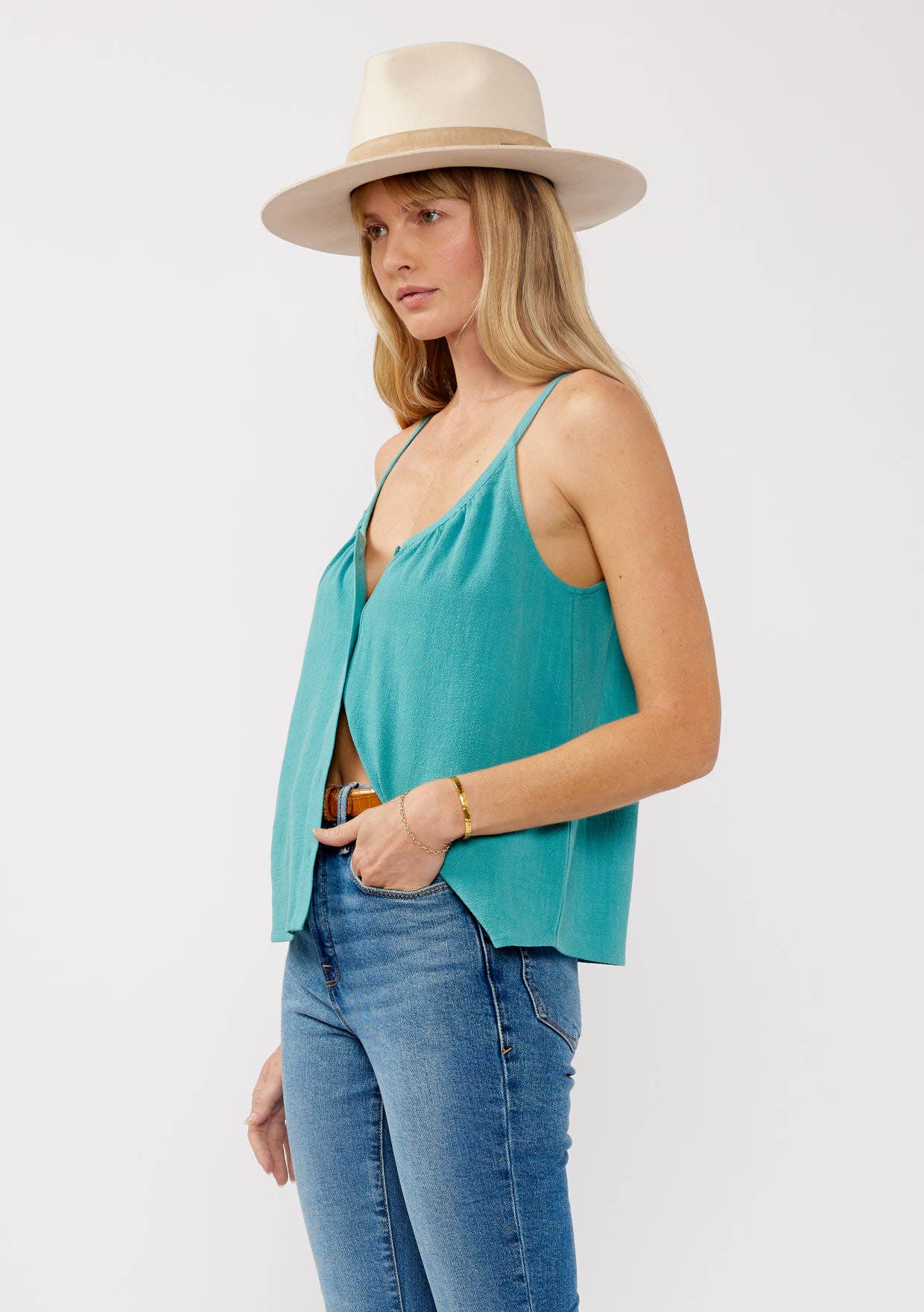 Woman wearing a teal Scoop Neck Button-Down Cami with jeans and a light beige wide-brim hat in a casual pose
