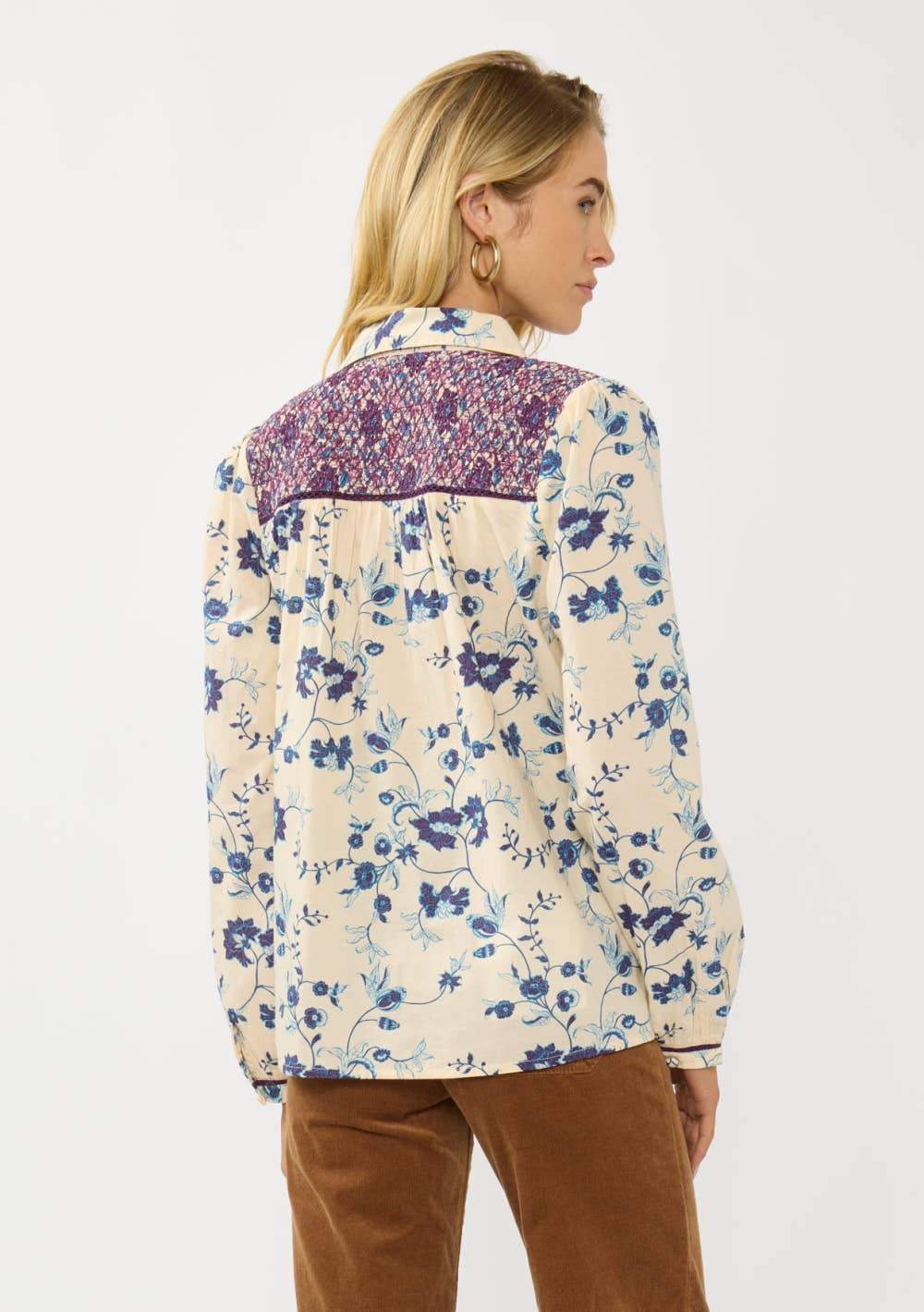 Woman wearing Long Sleeve Floral Blouse with Smocked Yoke in cream with blue and purple floral print, viewed from back