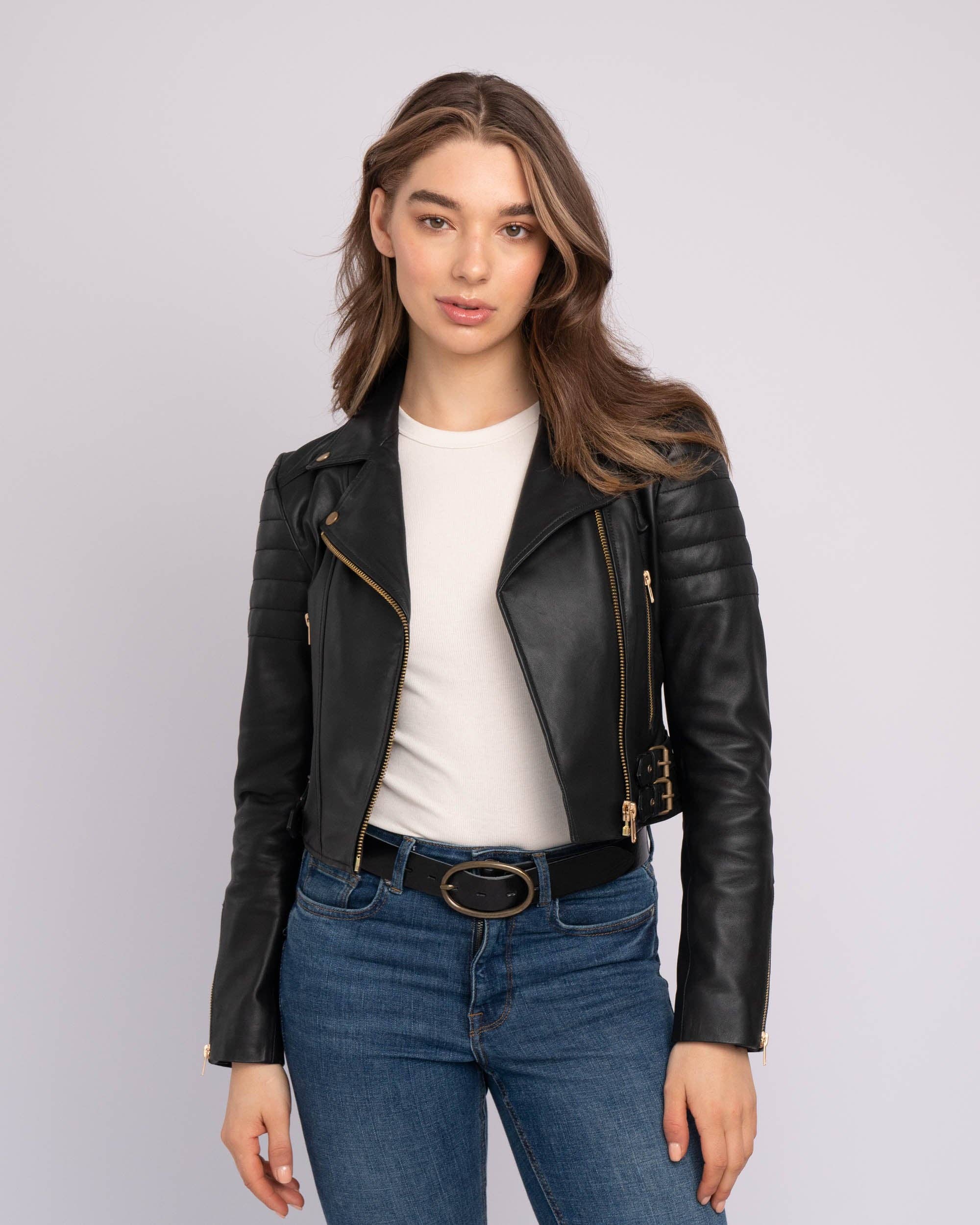 Woman wearing a sleek black Eureka | Leather Biker Jacket styled with white top and blue jeans for a bold look