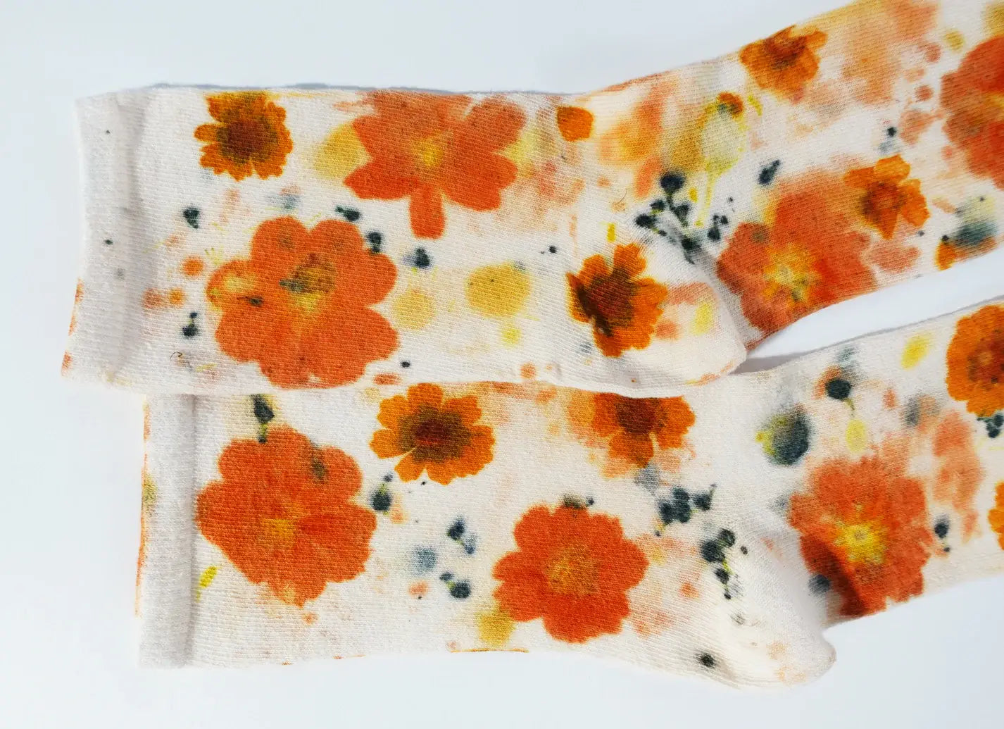 Pair of soft cotton socks with vibrant orange floral pattern called Flower Power Cotton Crew Sock