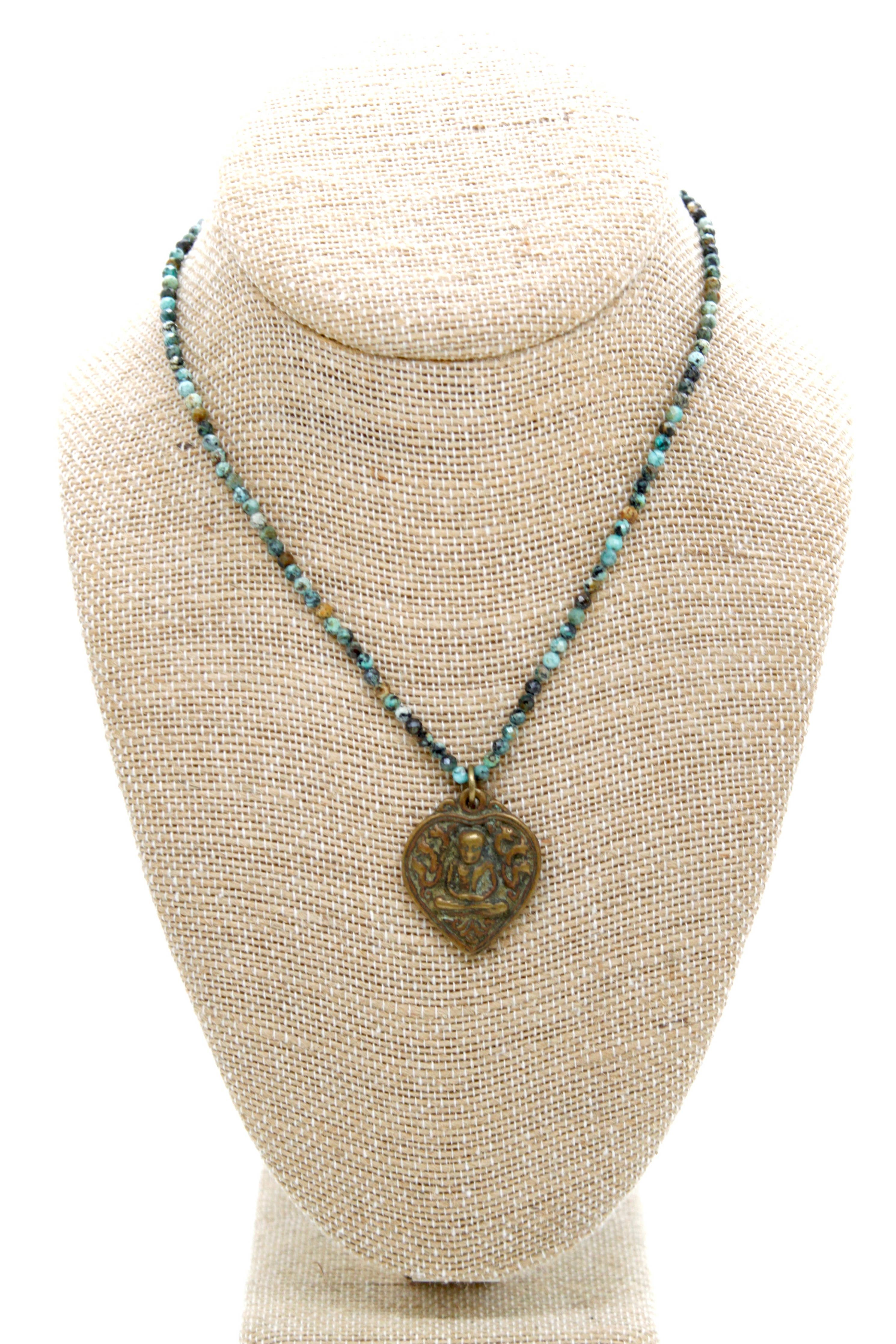 Buddha Necklace 117 - Faceted African Turquoise Necklace with bronze Buddha pendant on textured display bust
